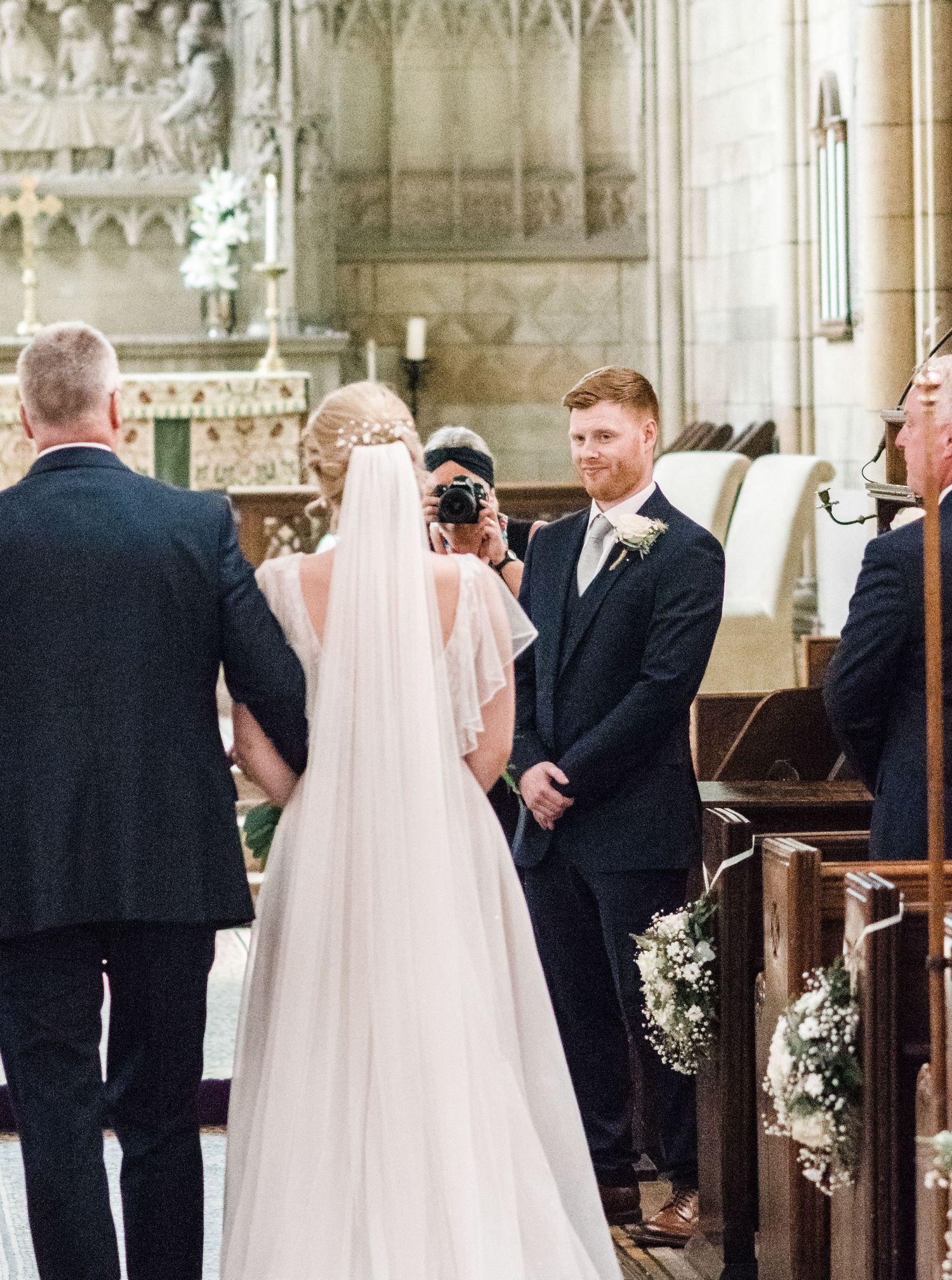 Traditional wedding ceremony taking place in an ornate cathedral with gothic architectural details.