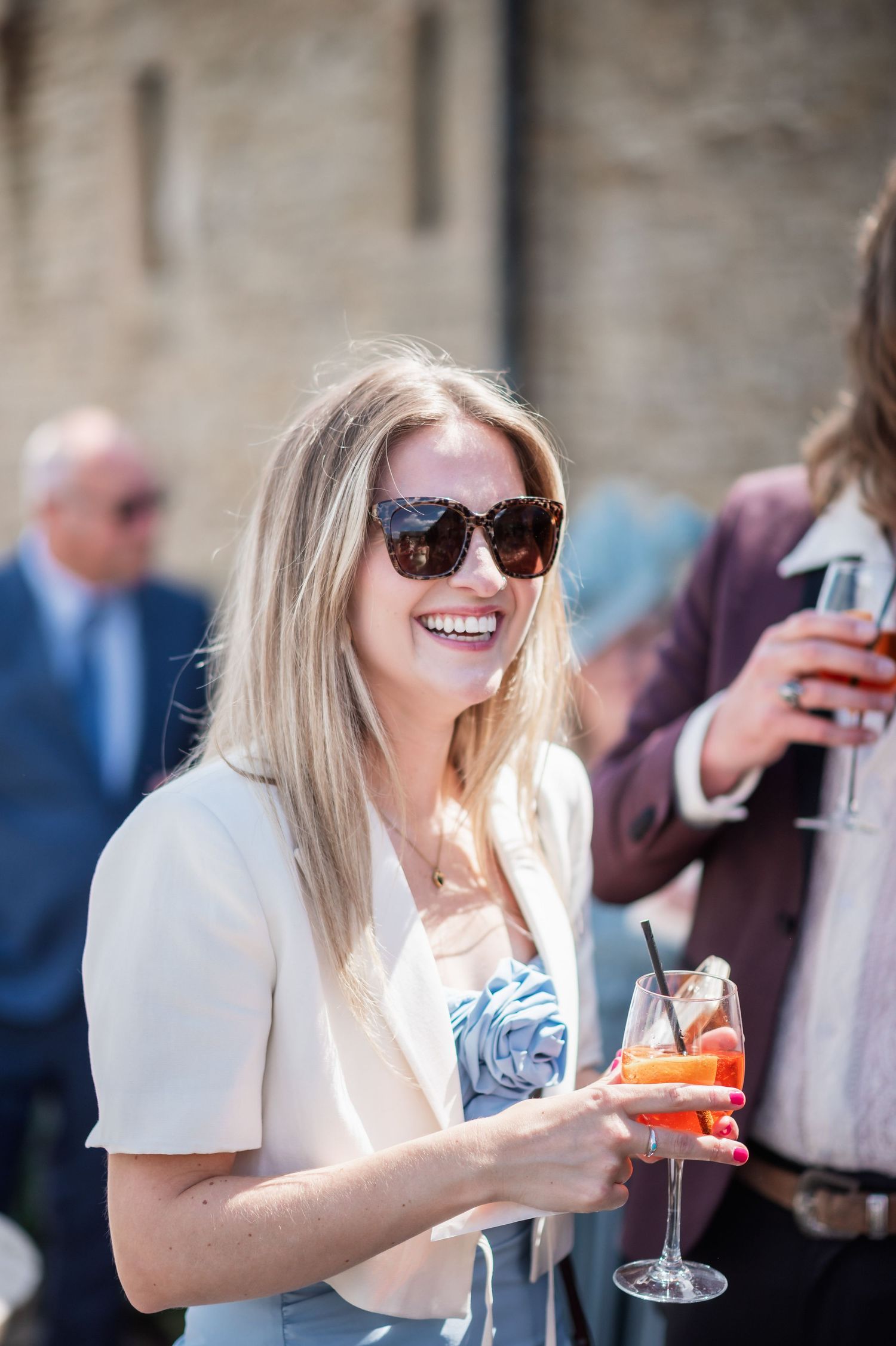 Wedding guest enjoying a celebratory cocktail at outdoor reception.