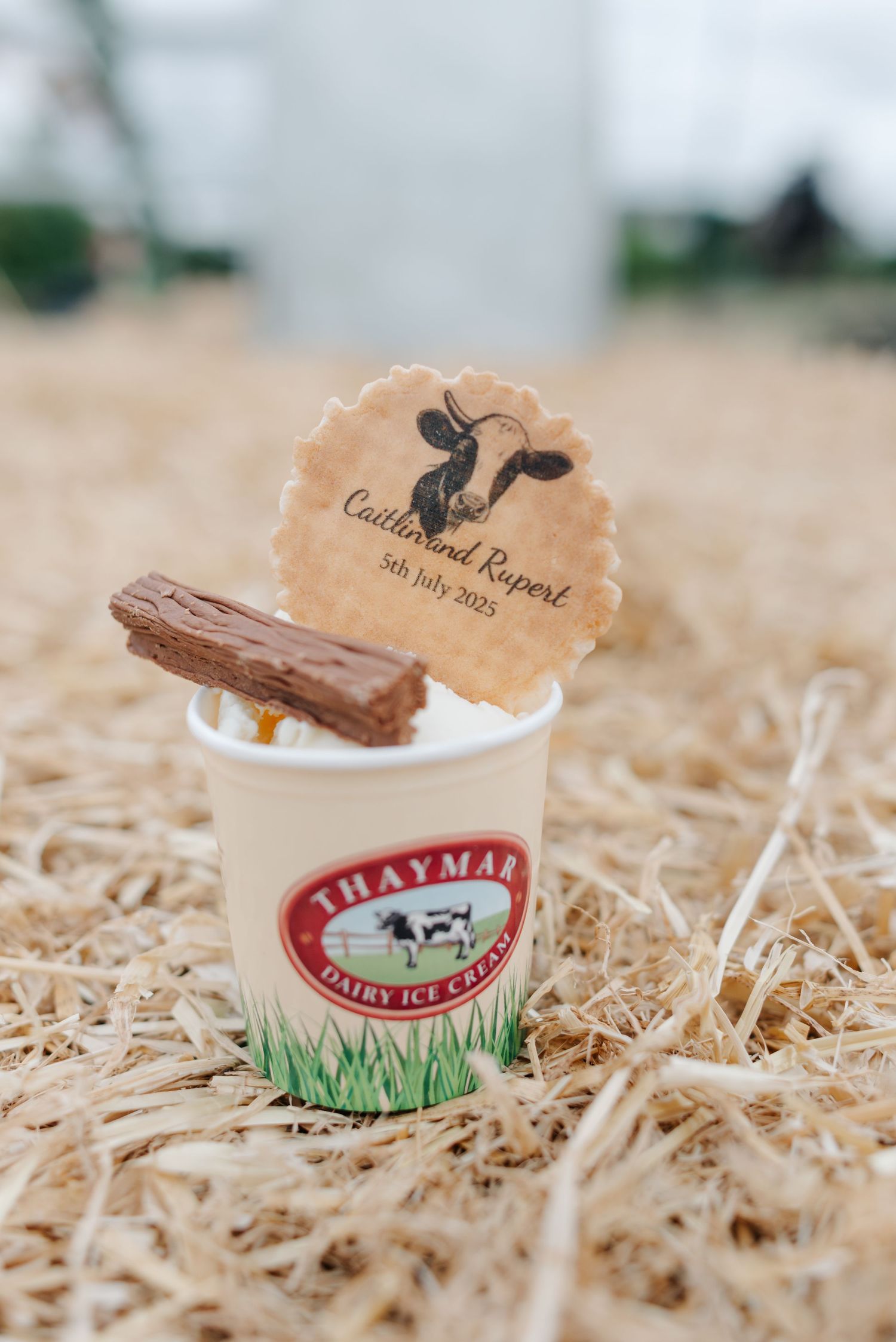 Ice cream containers from Thaymar dairy farm arranged on straw with custom wedding labels.