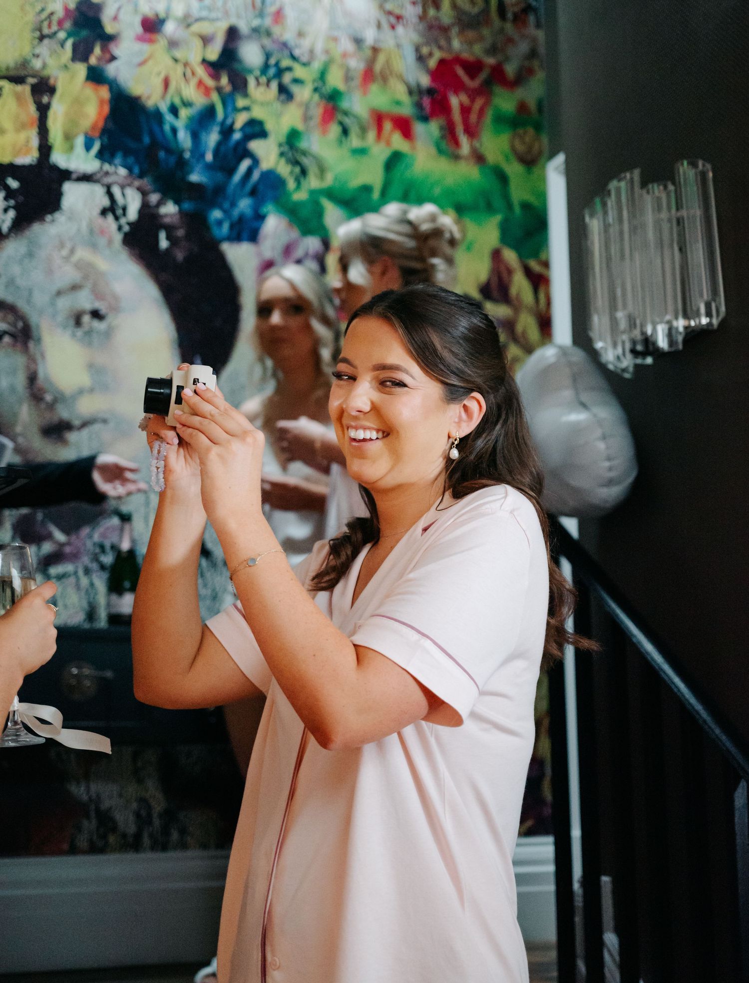 People in light colored attire taking photos with cameras at an event.