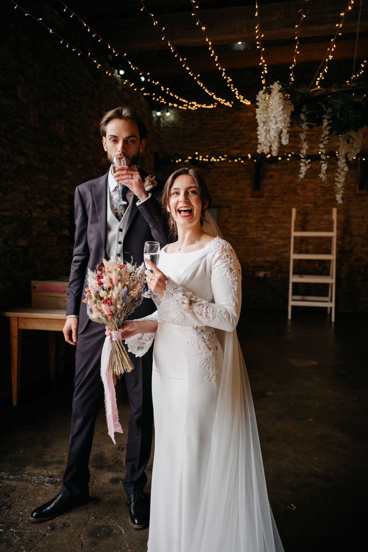A joyful wedding celebration in a rustic venue with string lights and exposed brick walls.