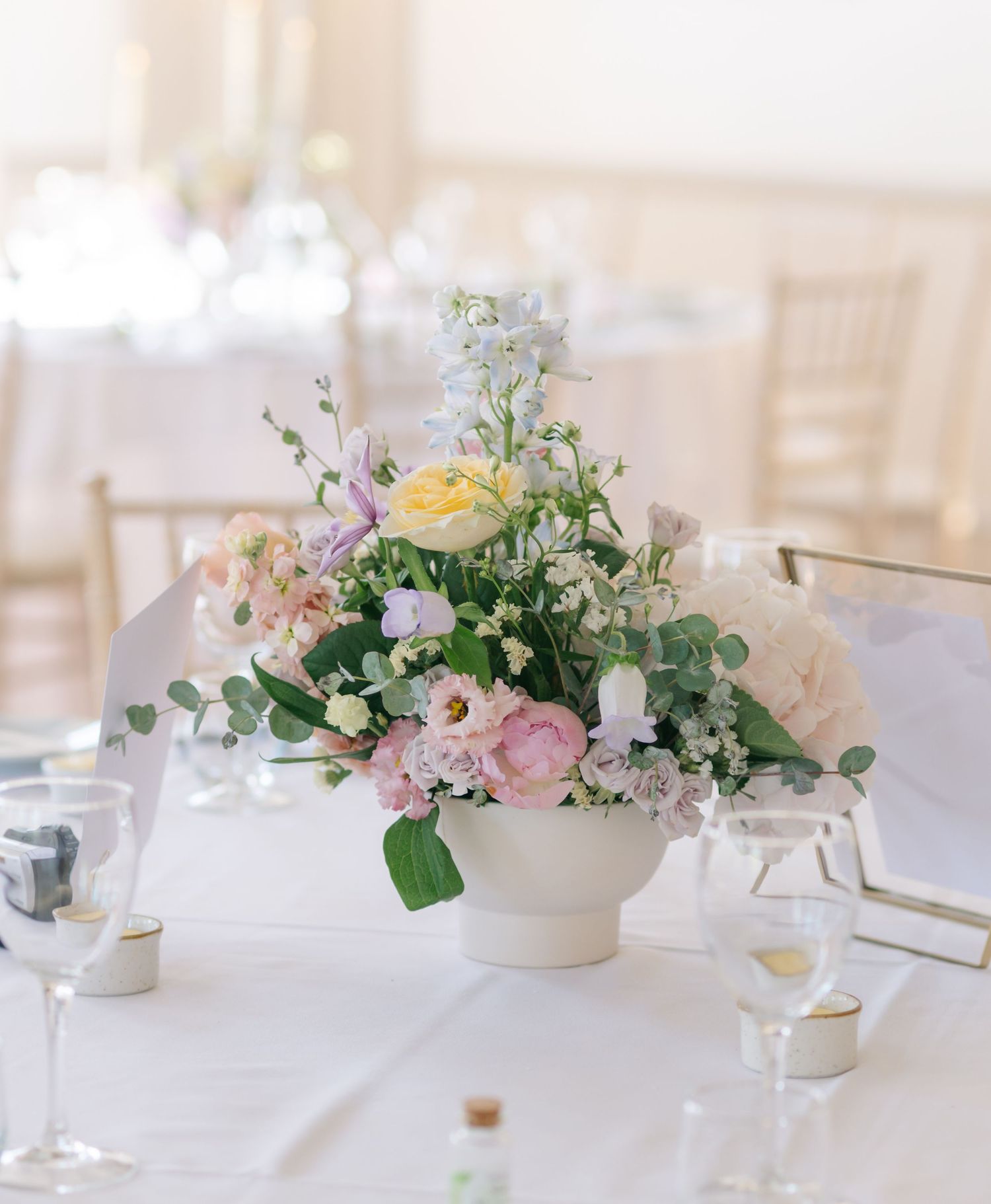 Elegant floral centerpieces with pink and white flowers on wedding reception tables.
