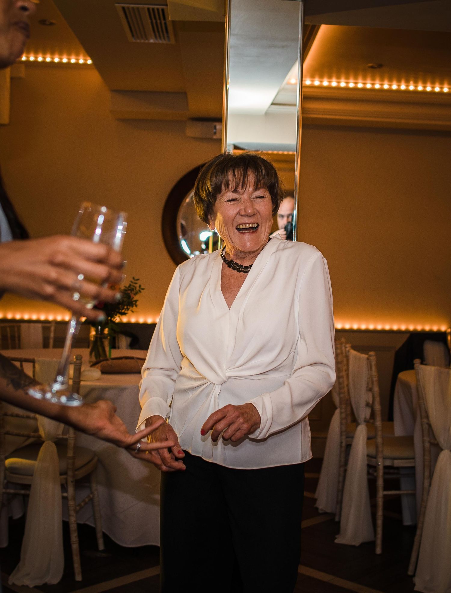 A guest enjoying a celebratory moment at an indoor reception with ambient lighting.