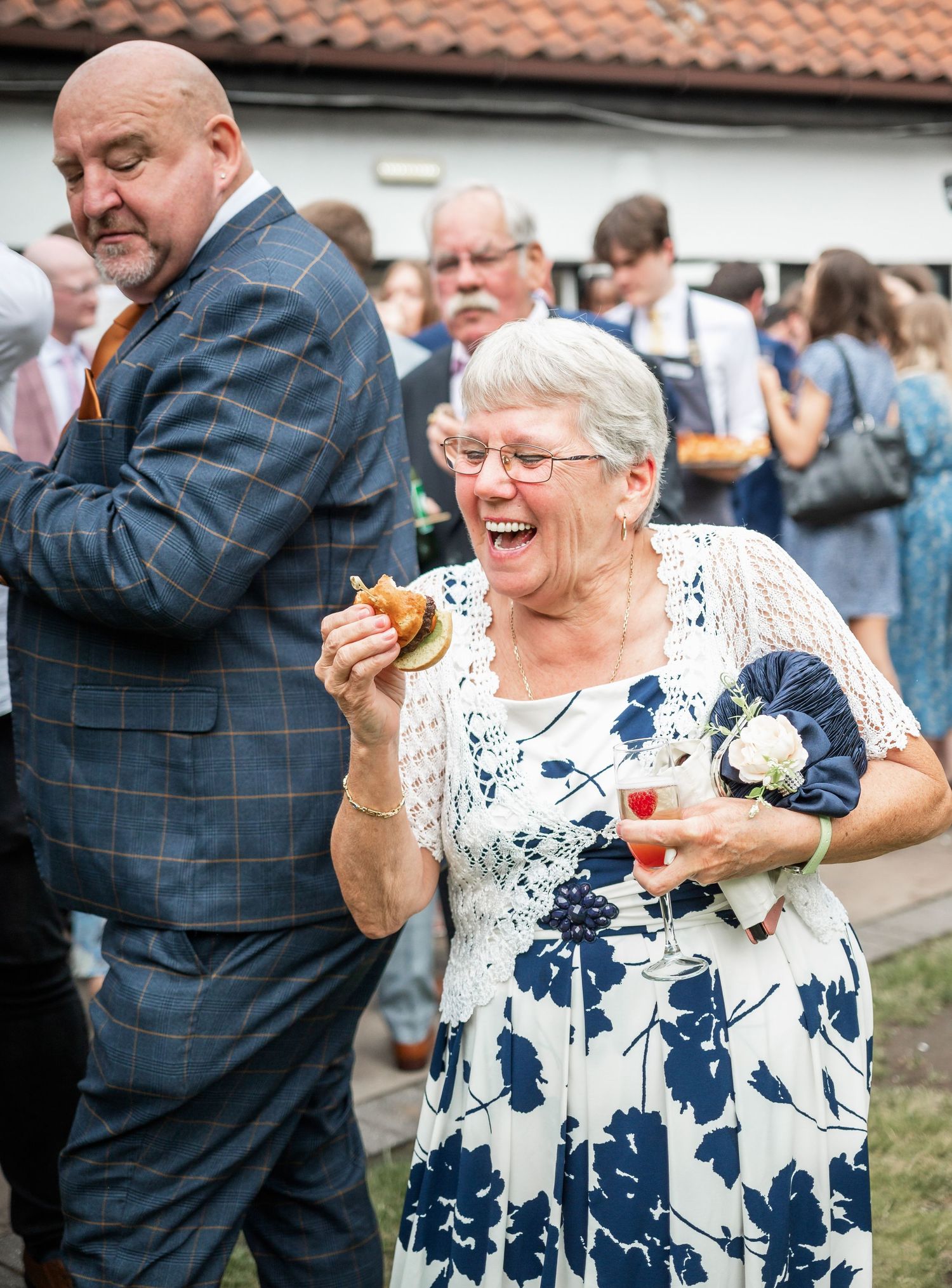 Wedding guests enjoying themselves at an outdoor reception with festive expressions.