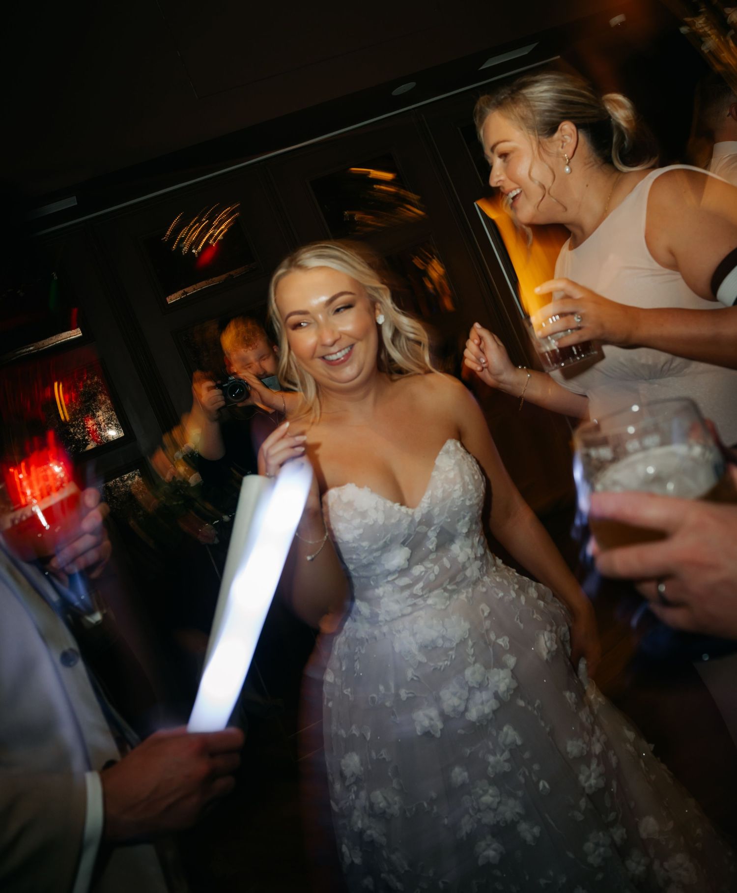 Dancing and celebration at dimly lit wedding reception with strobe lights.