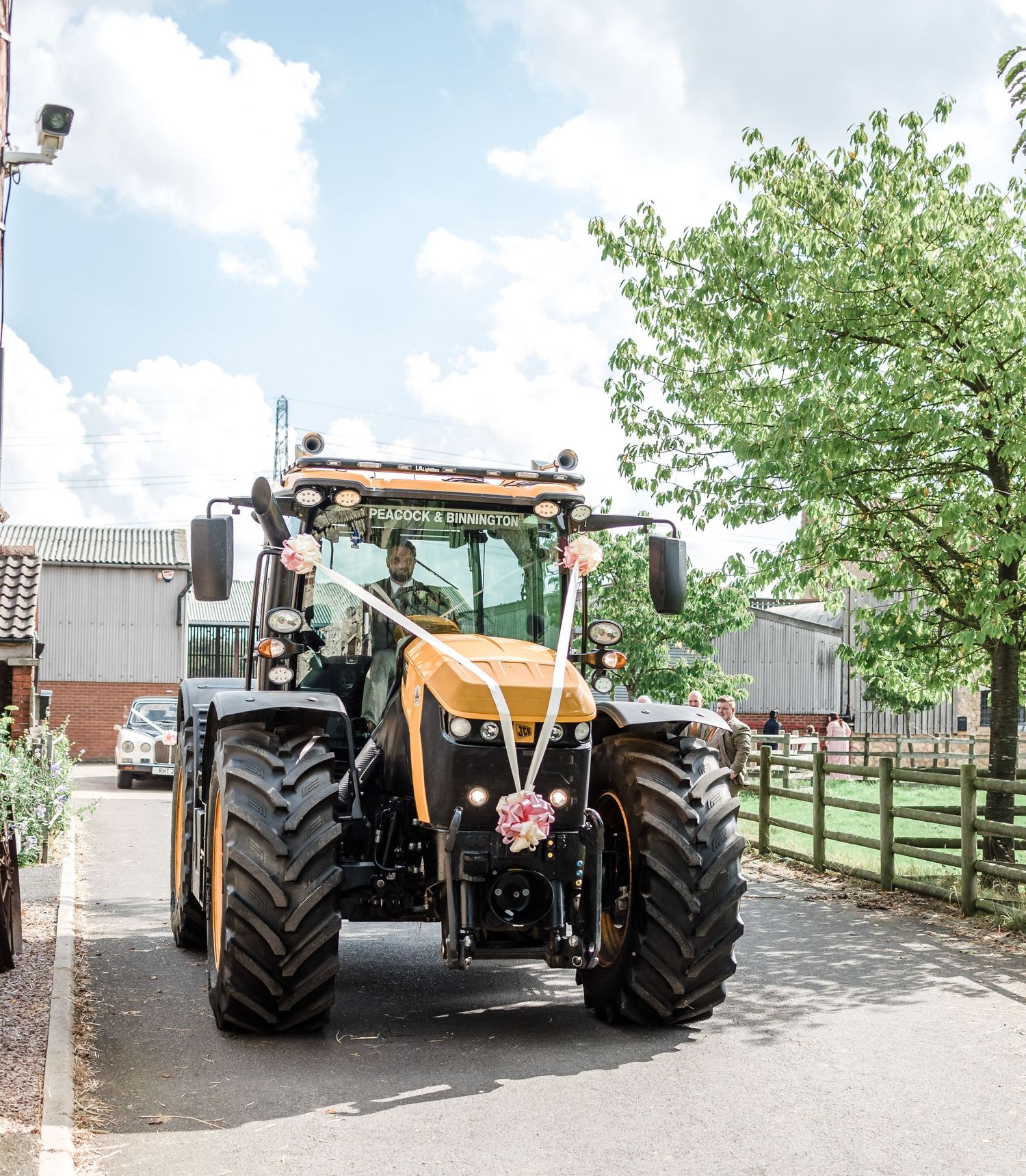A large yellow and black agricultural tractor parked on a residential street.