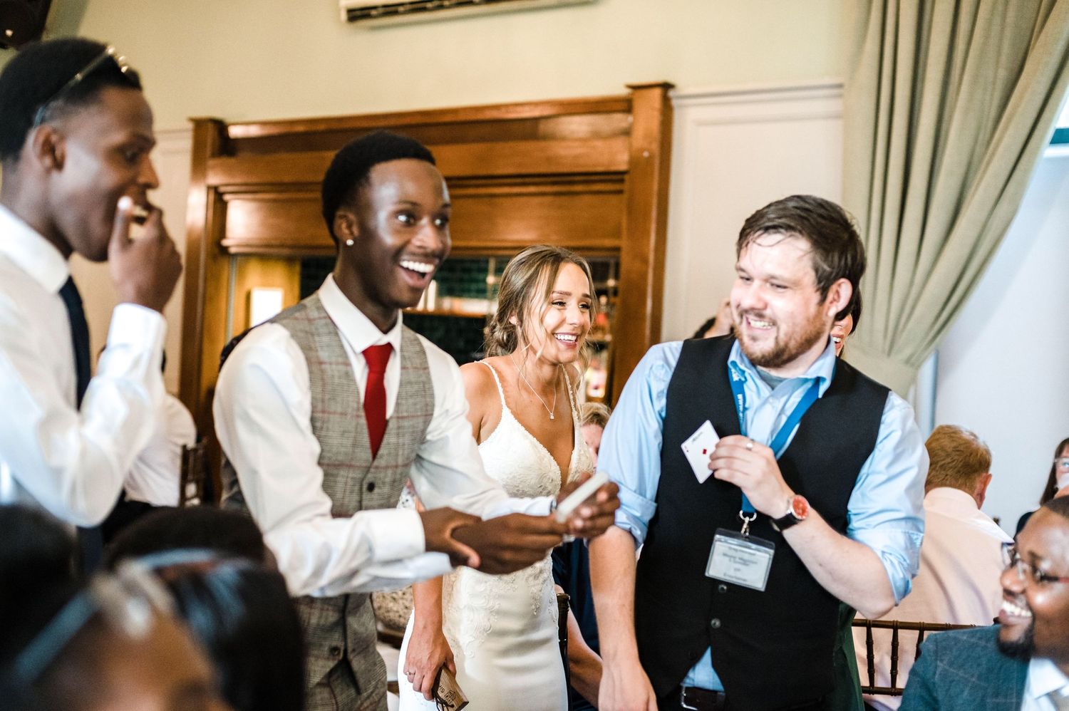 Wedding guests sharing joyful moments and laughter during reception speeches.