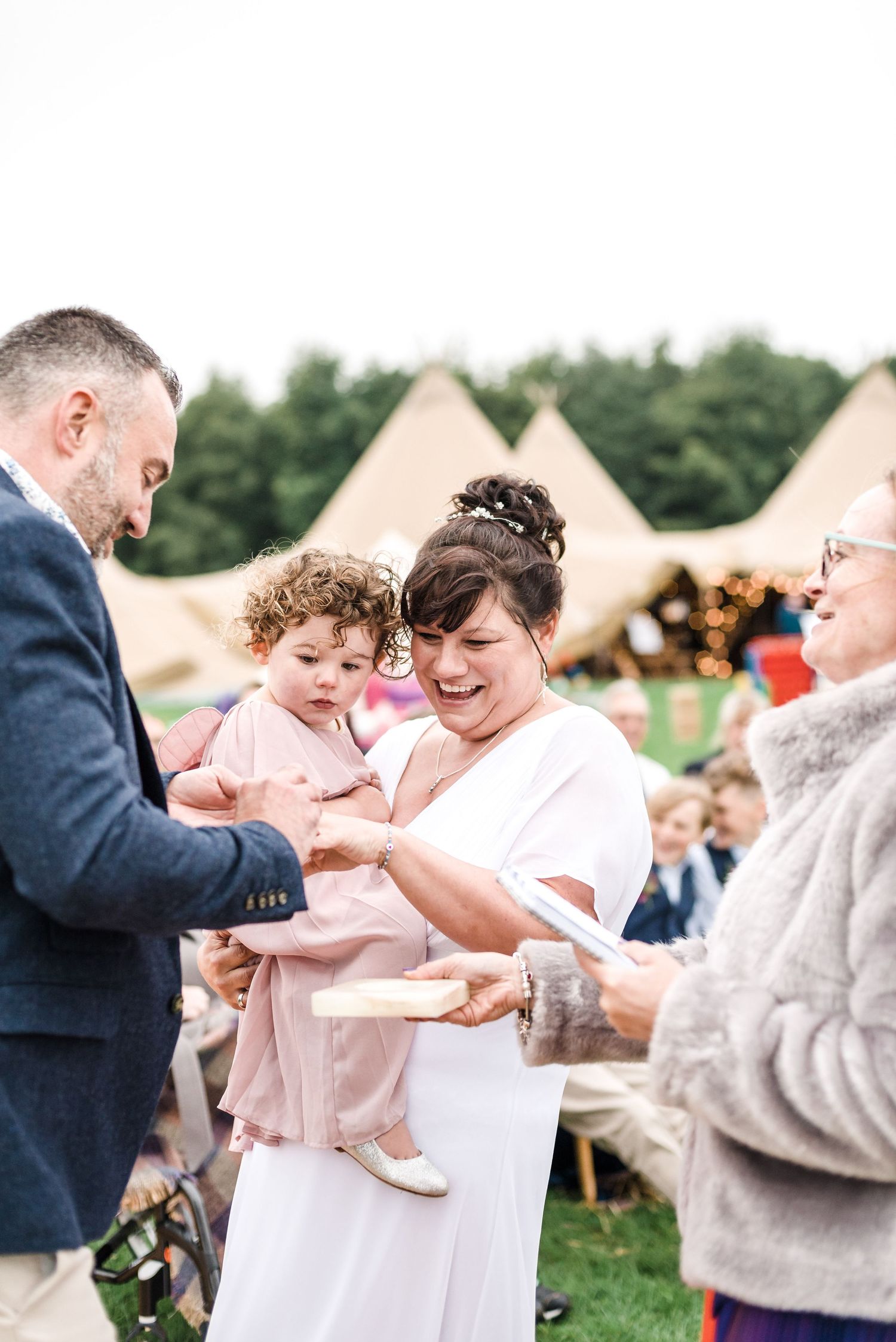 Wedding ceremony moment with guests seated beneath teepee tents.