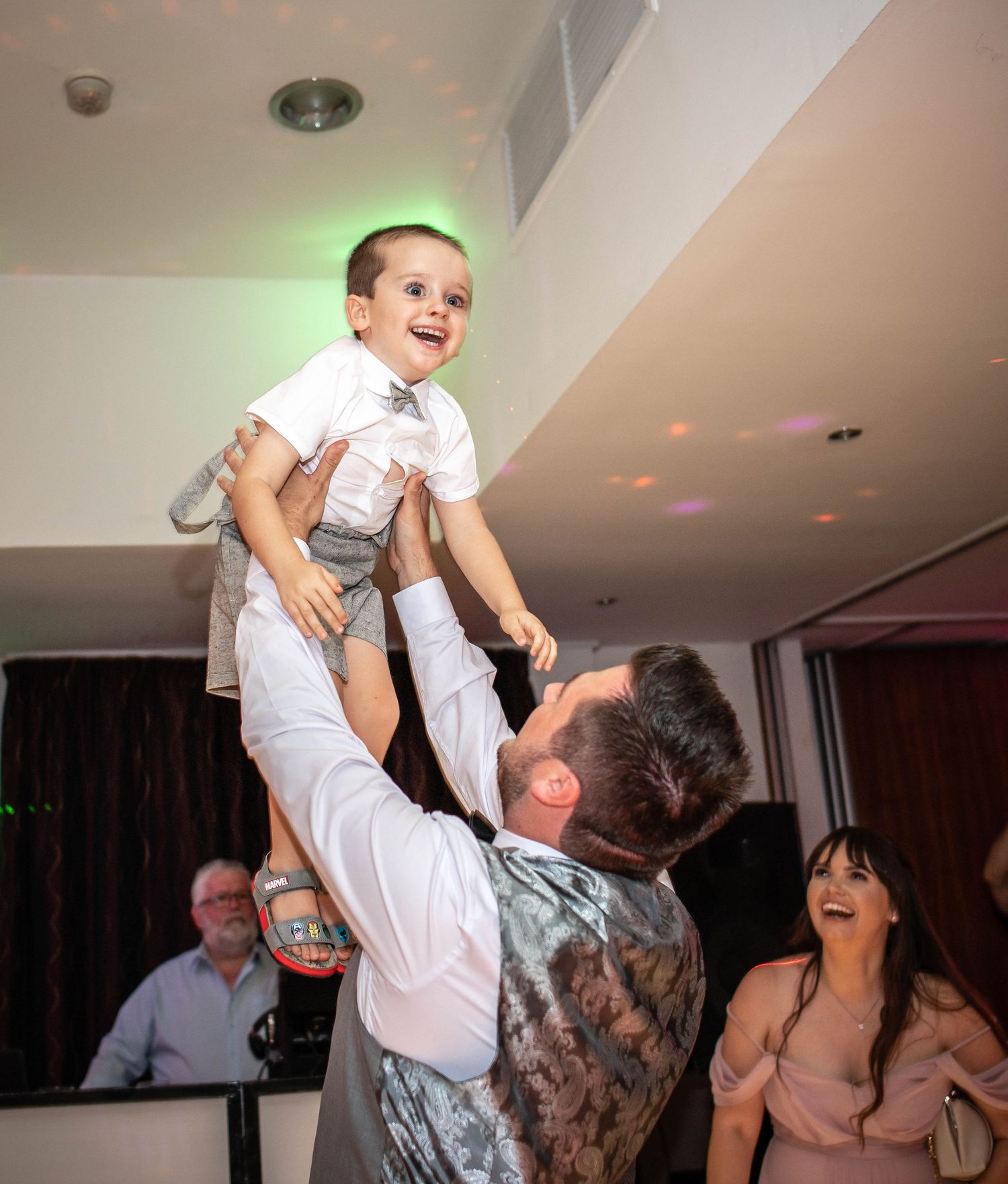 A joyful celebration moment during a wedding reception with party lights.