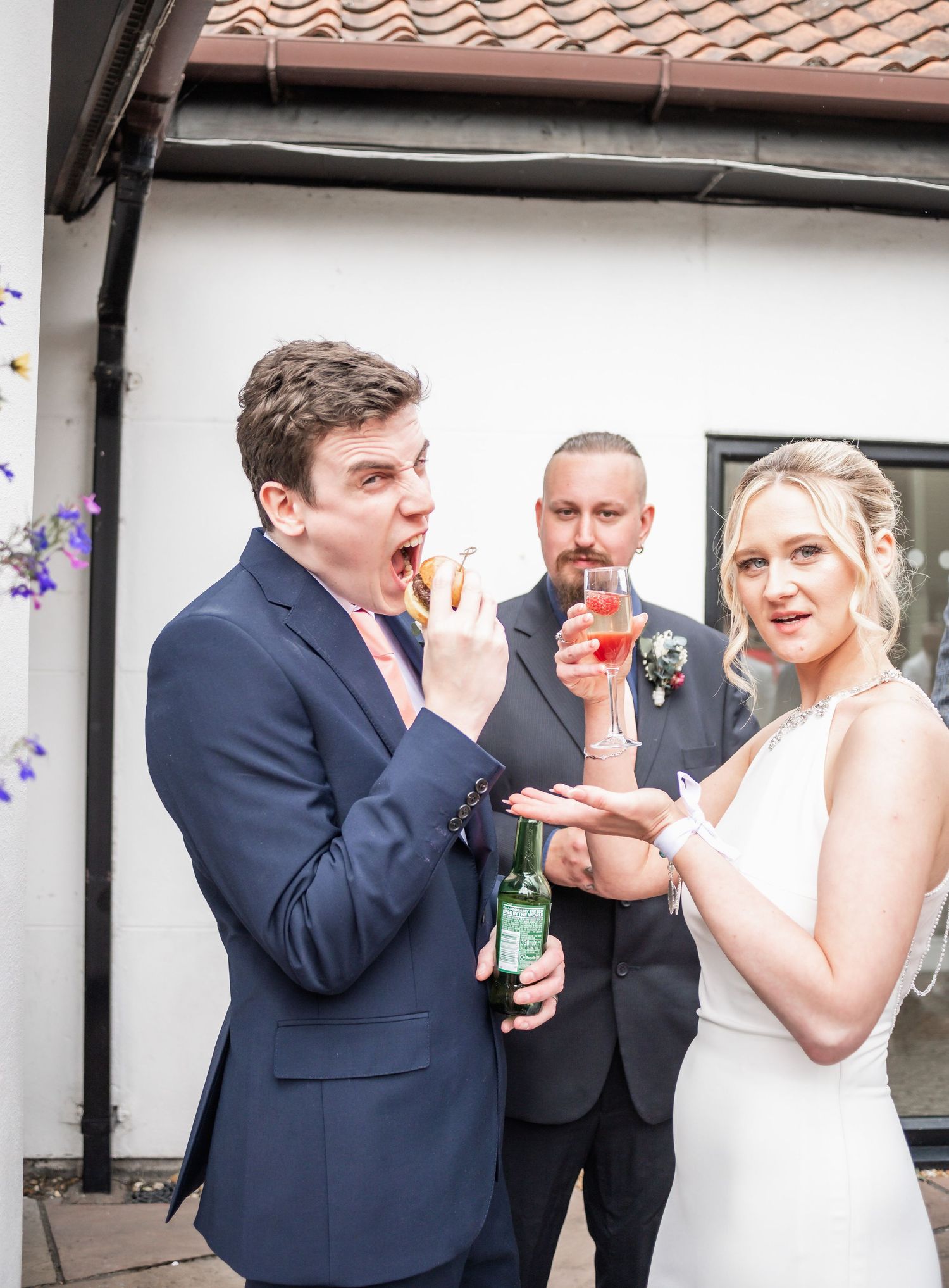 Wedding guests enjoying casual outdoor celebration with drinks and snacks.