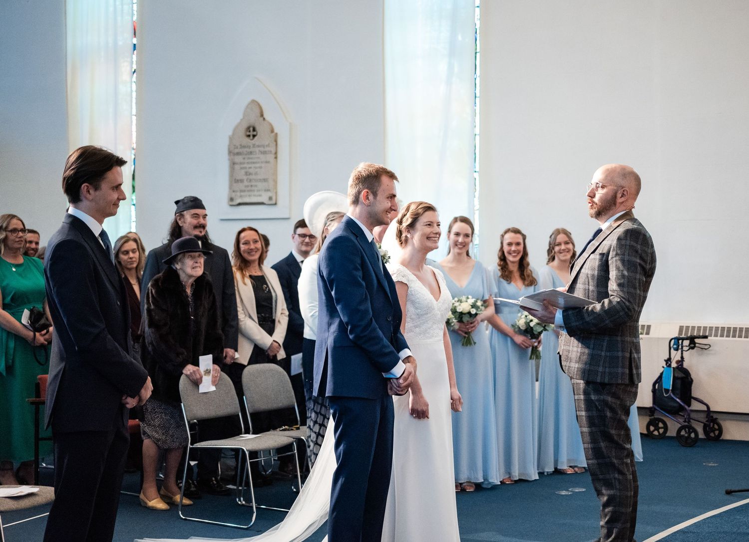 Wedding ceremony moments captured indoors showing guests and celebrations in a bright modern space.