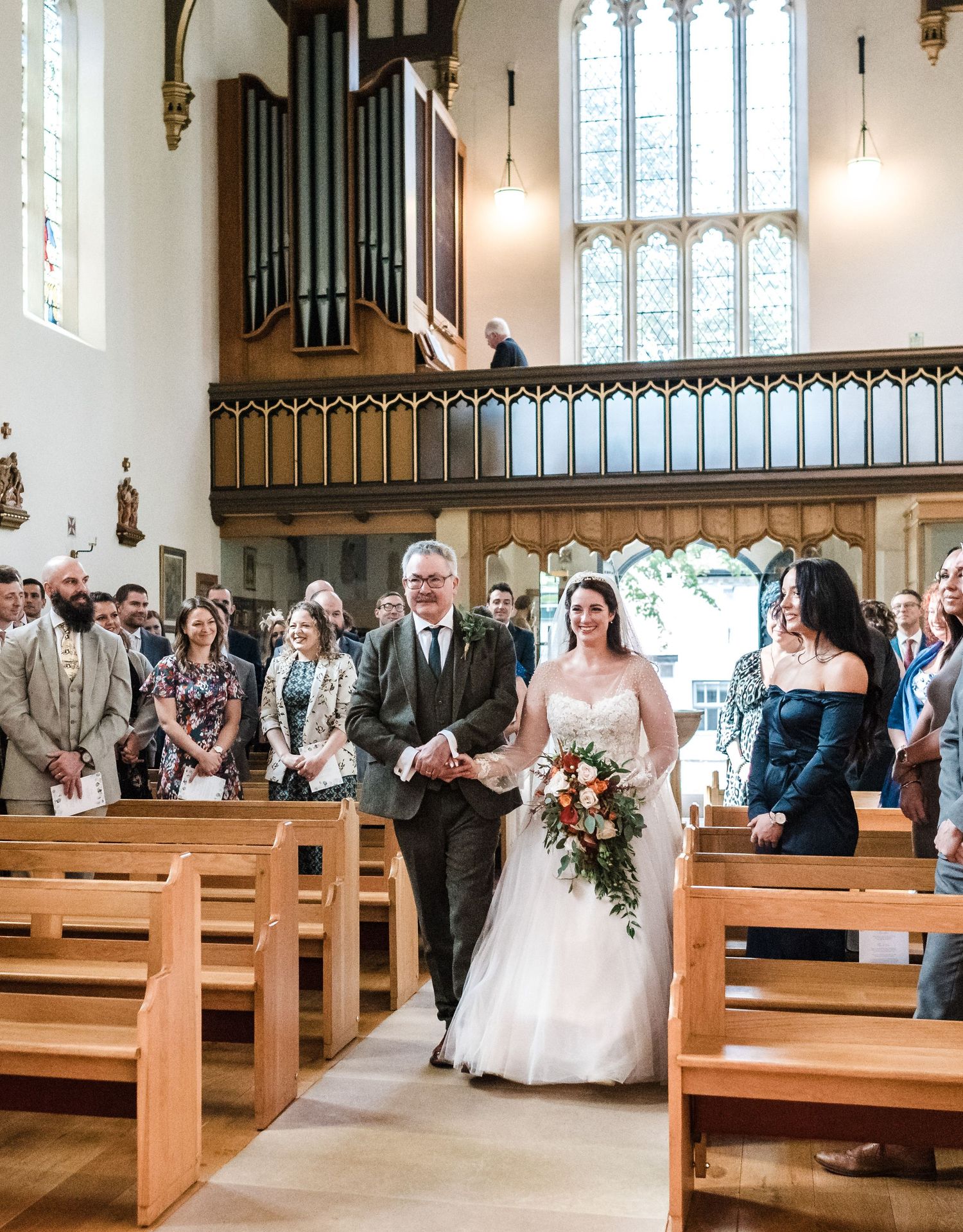 Traditional church wedding processional down the aisle with organ pipes in background.