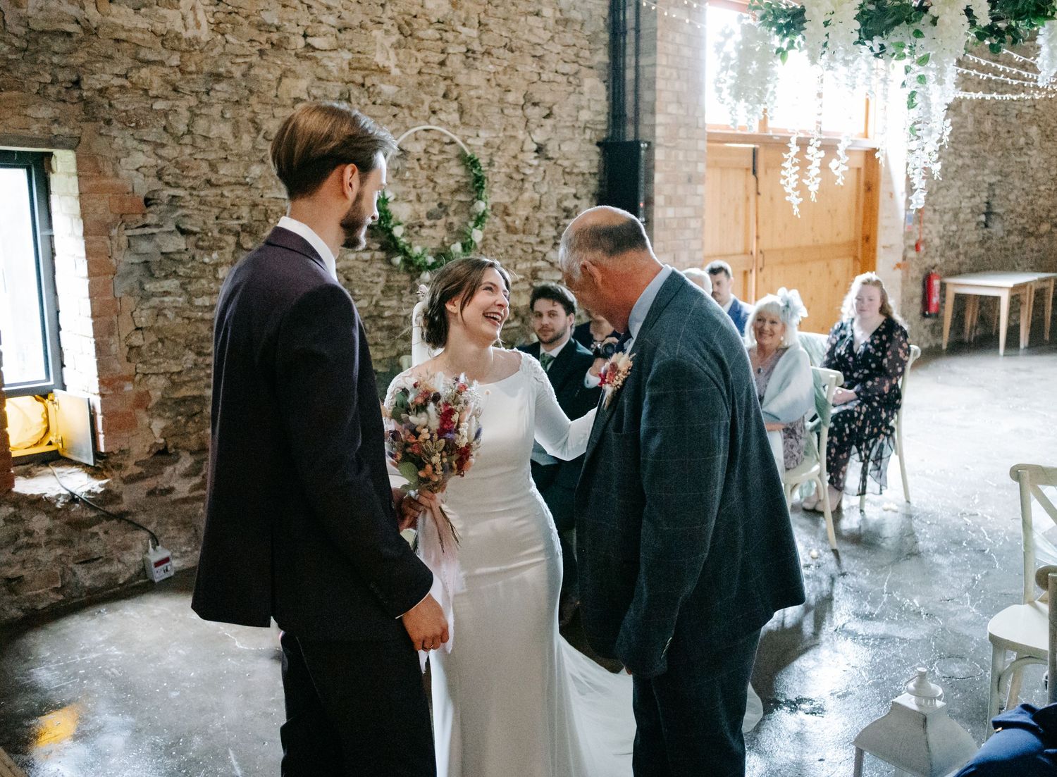 Wedding ceremony moments captured in a historic stone building with warm lighting.