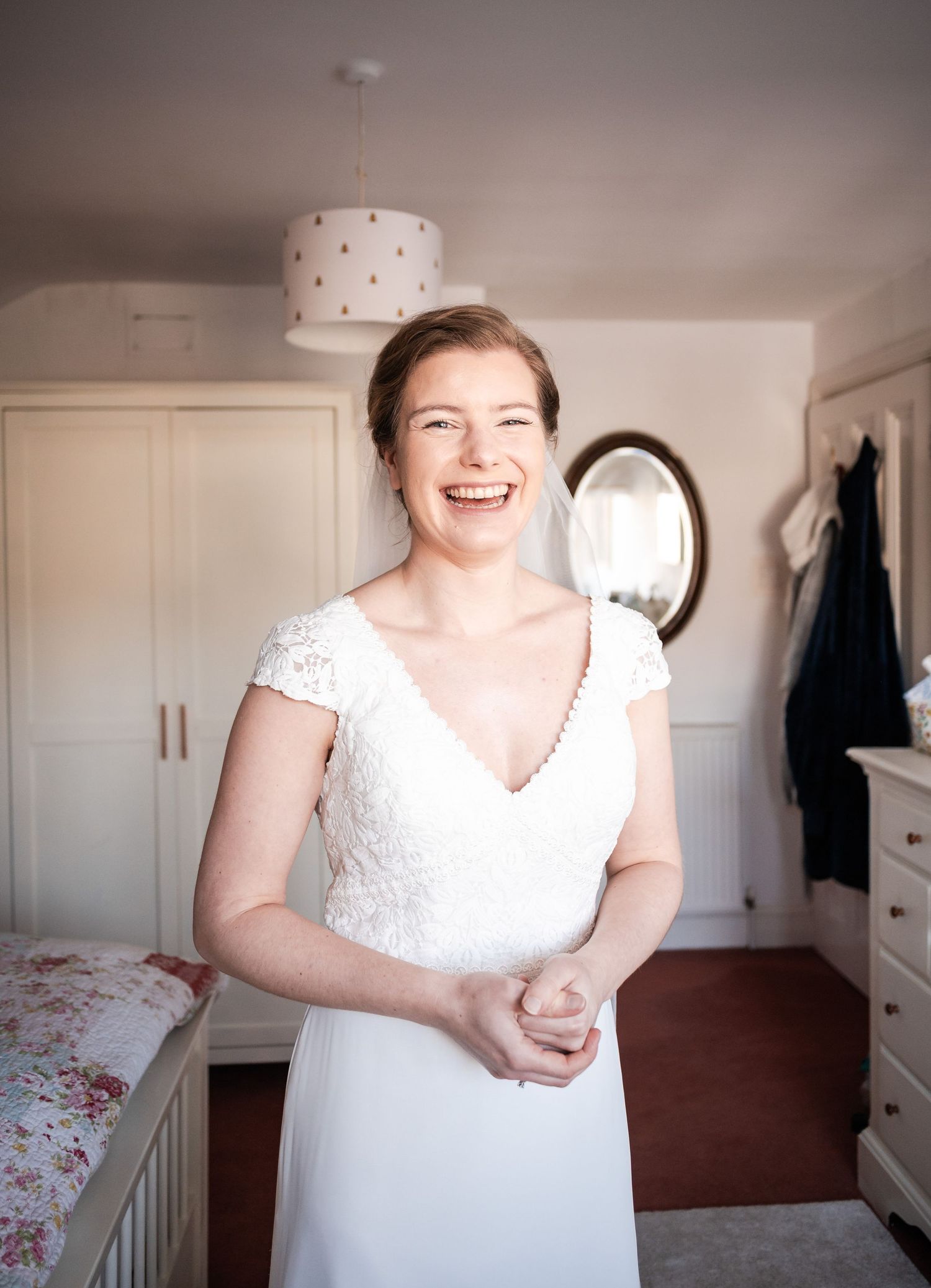 A series of candid moments showing a person in a white wedding dress laughing and expressing joy in a bedroom setting.