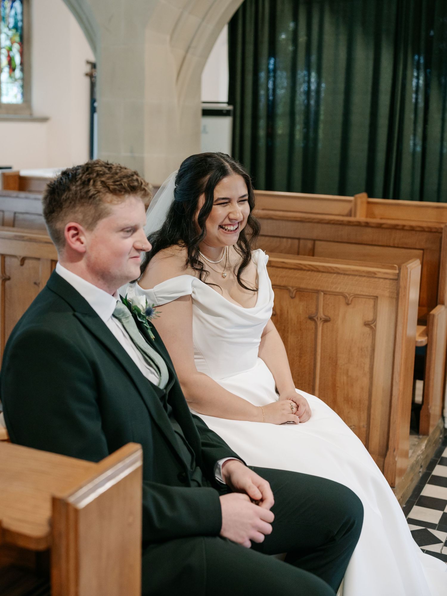 Wedding ceremony attendees seated in wooden church pews during the service.