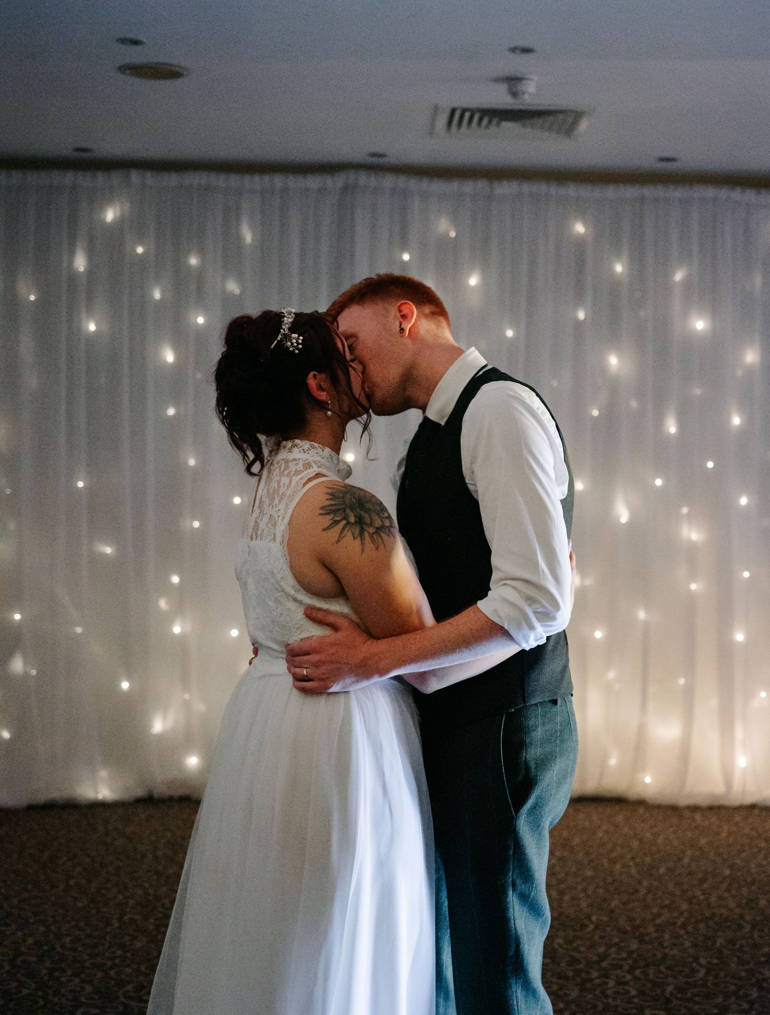 Romantic first dance moment against a backdrop of twinkling fairy lights.