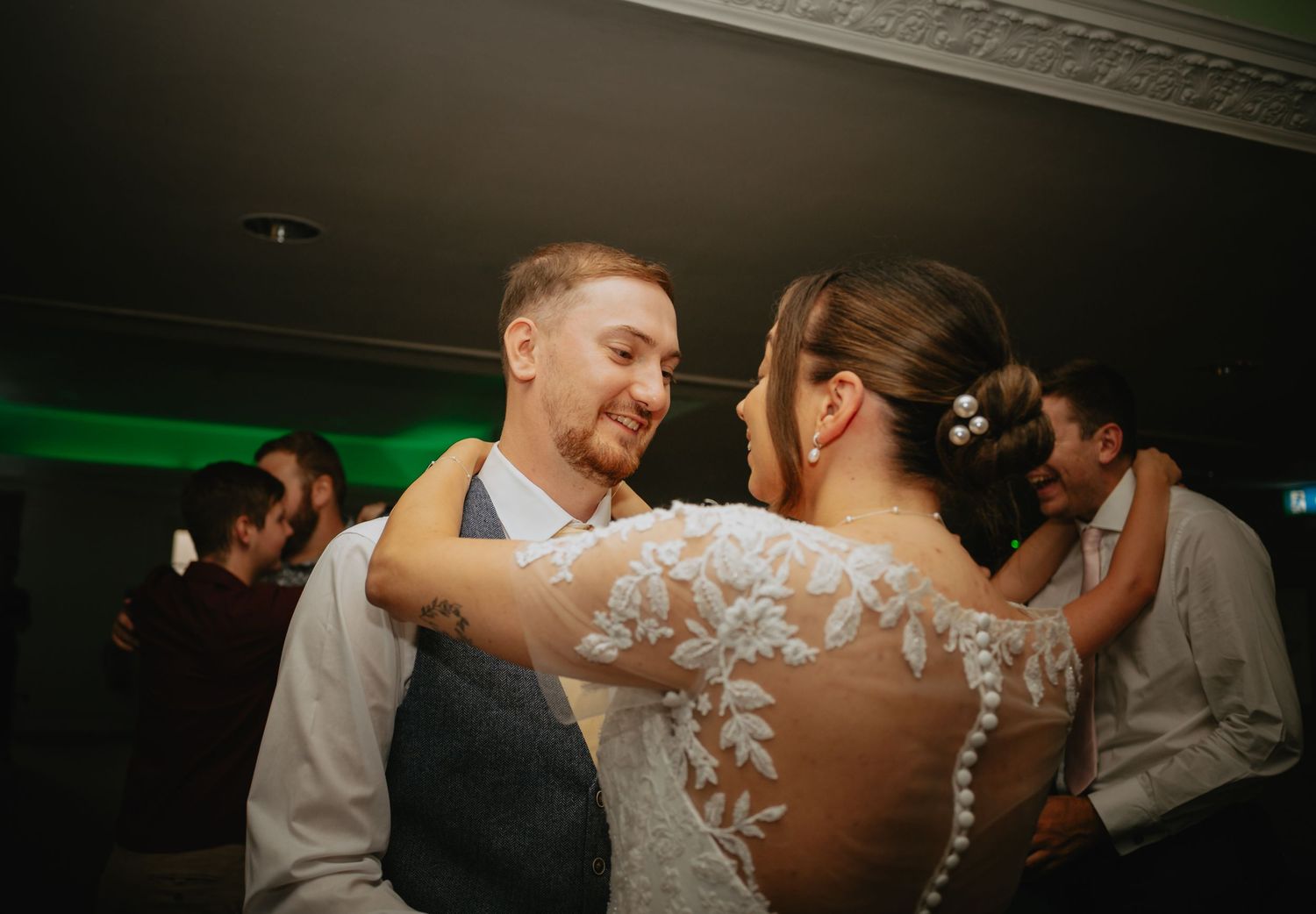 Couples dance together during romantic evening wedding reception.