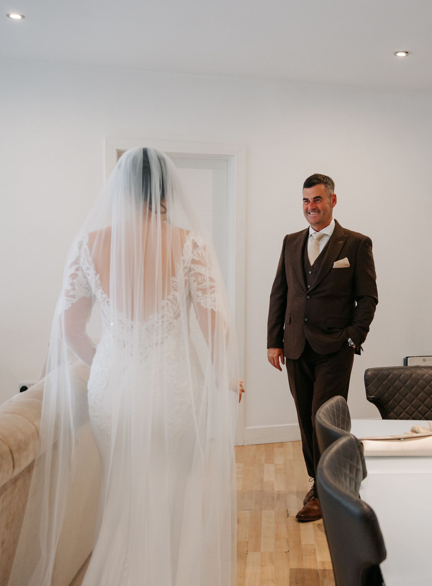 A series of emotional wedding day moments captured in a minimalist white room with hardwood floors.