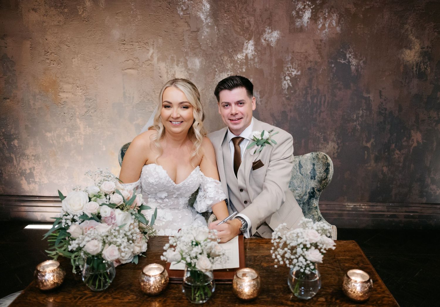 Elegant wedding reception table setup with white floral centerpieces and candlelight.