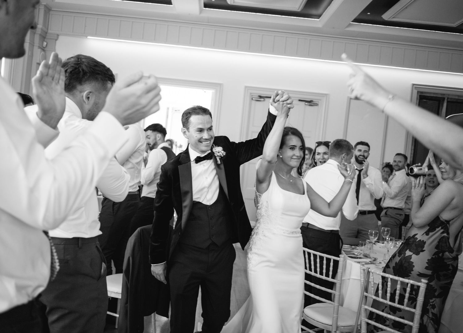 Wedding reception celebration with guests dancing and enjoying festivities in an indoor venue.