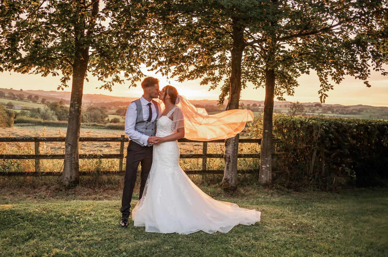 Romantic wedding portrait of a couple in a garden setting during golden hour sunset.