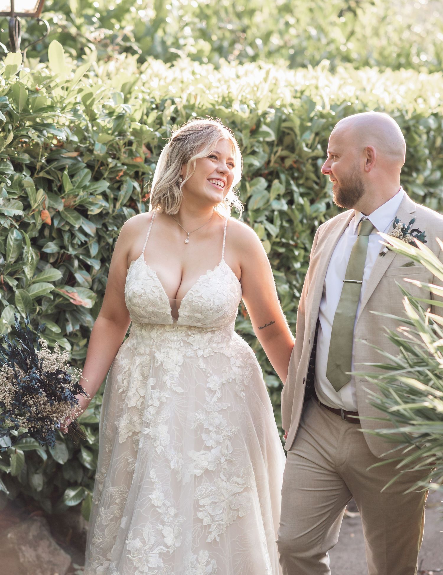 Romantic garden wedding portrait with couple in beige and white attire.