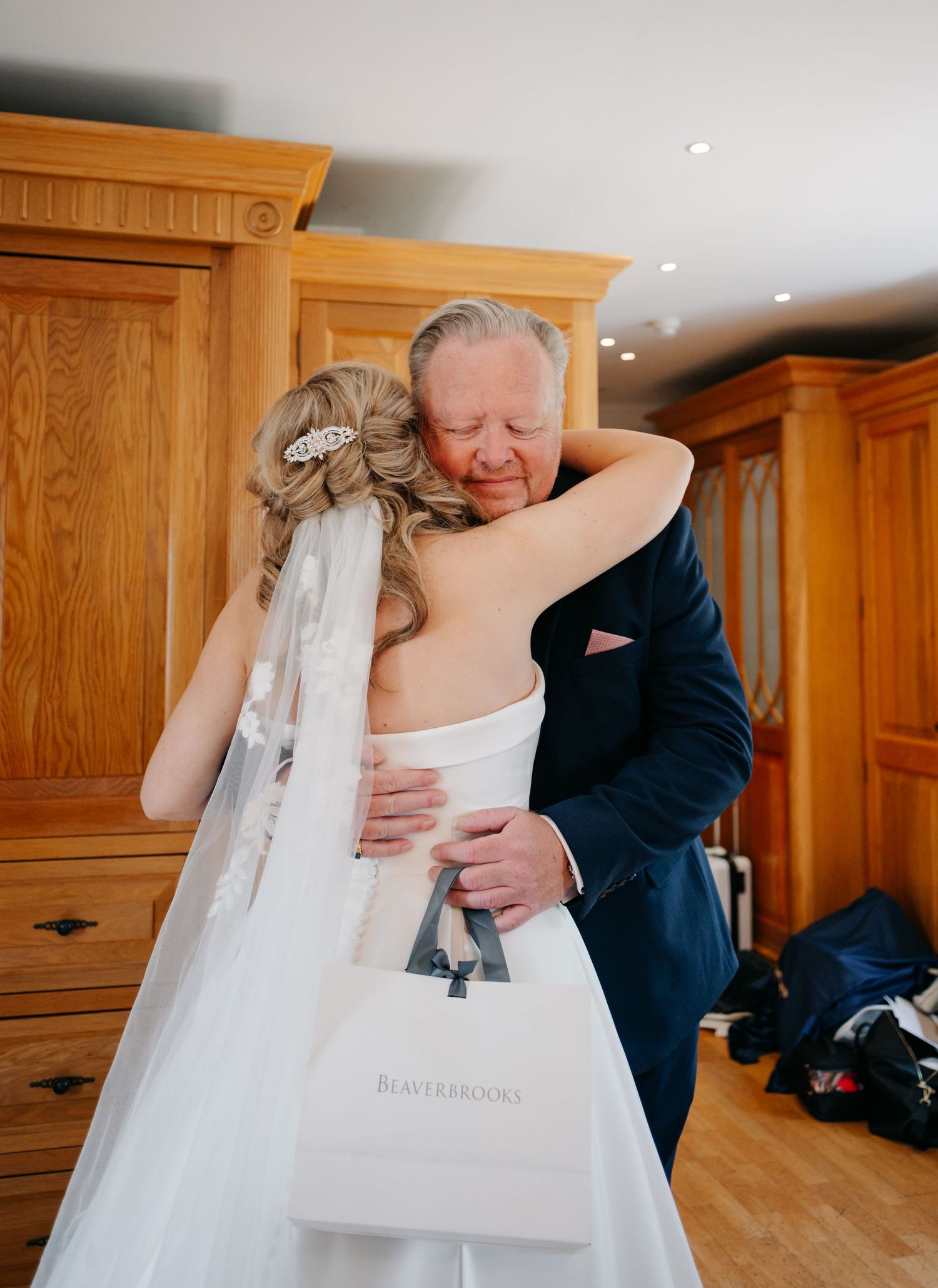 Emotional moment shared during wedding preparations as a white dress is revealed from its garment bag.