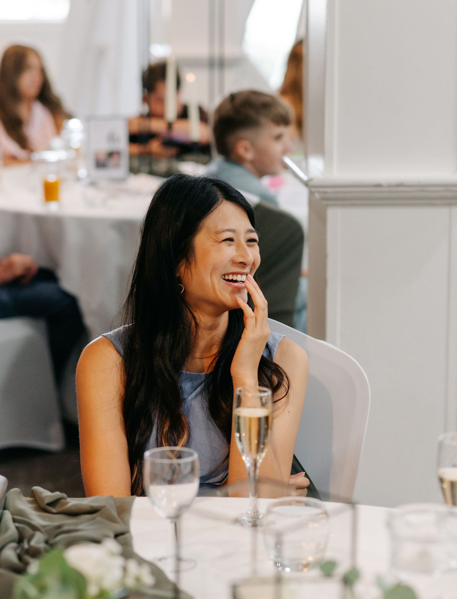 Wedding guests enjoying conversation and drinks at elegant indoor reception.