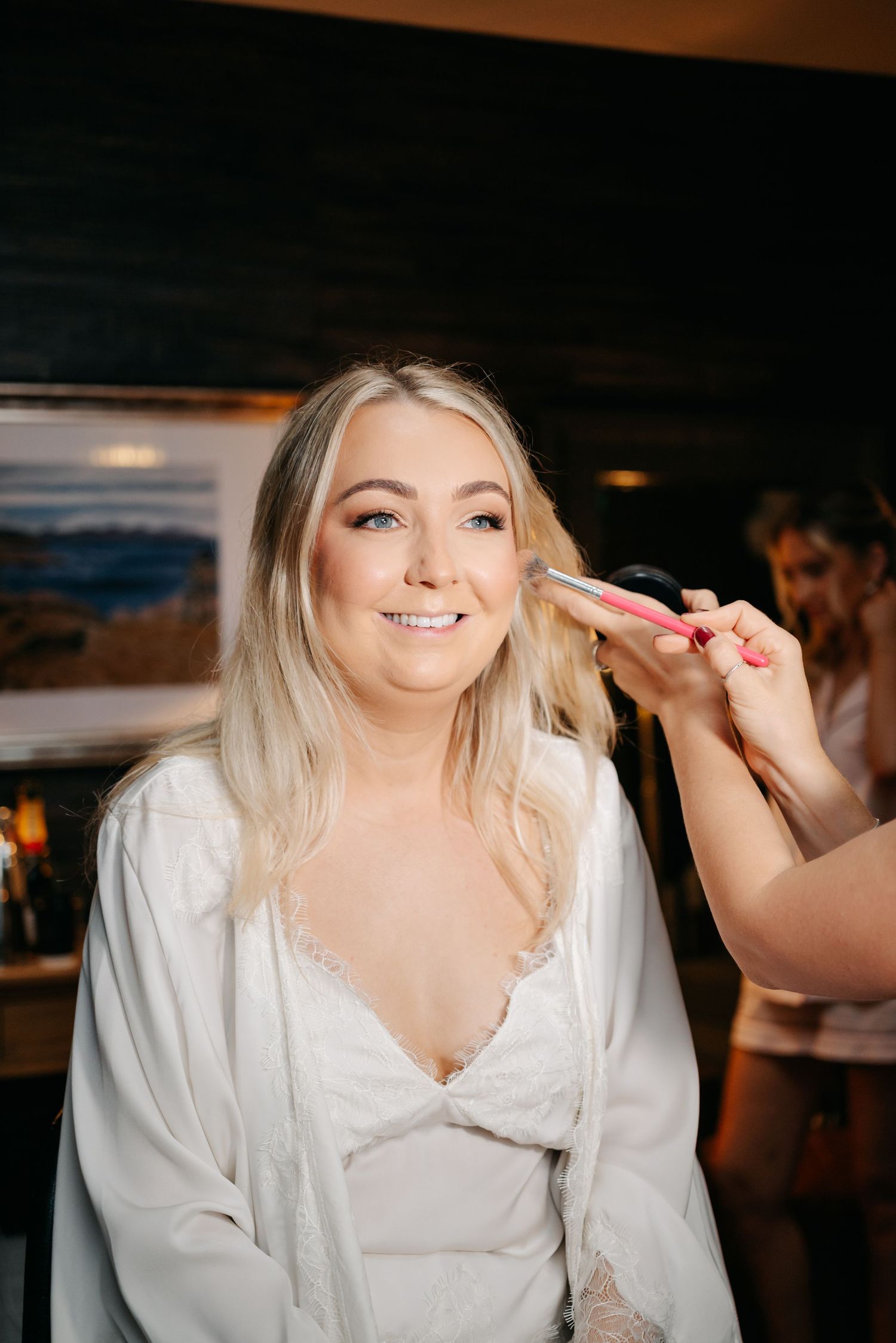 Getting ready on wedding day morning with hair and makeup preparations in white robe.