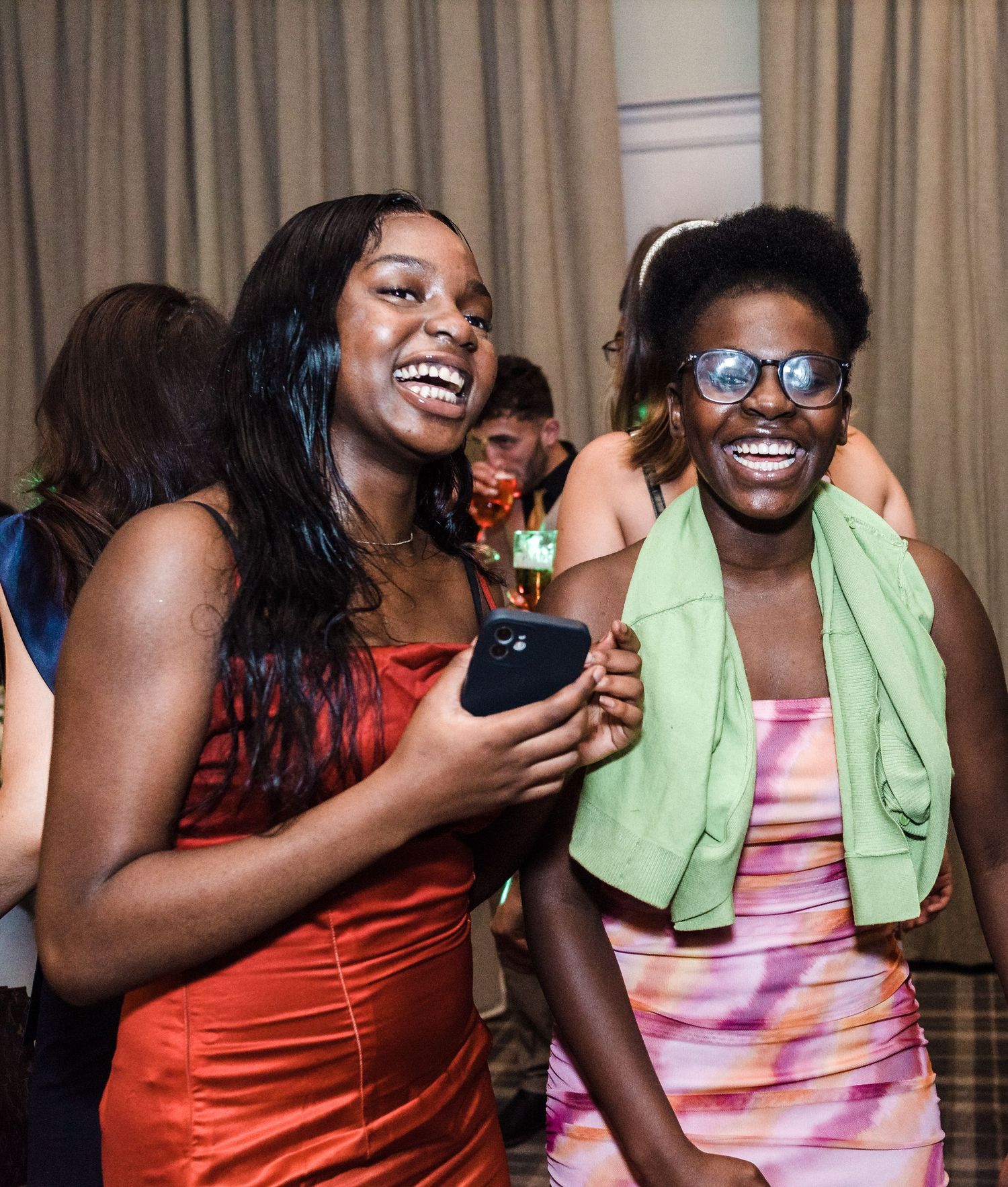Party guests enjoying themselves with bright smiles at indoor celebration.
