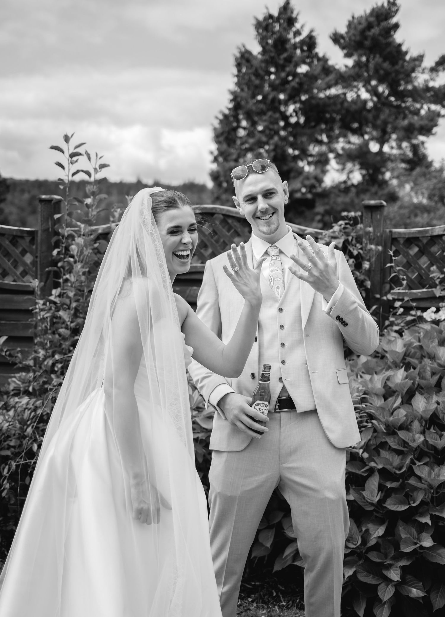 Couple sharing playful moments in a garden setting during their wedding photoshoot.