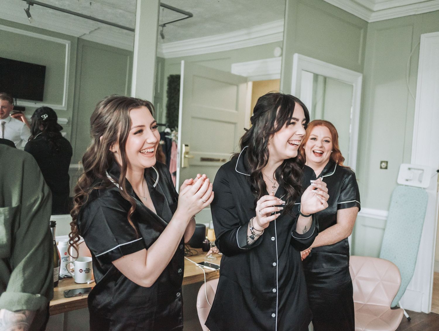 A group in matching black uniforms share laughter during an event preparation.