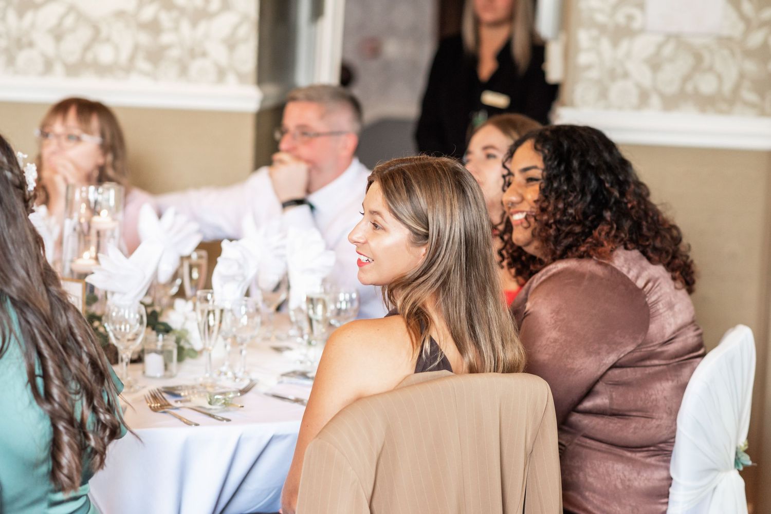 Wedding reception dinner with guests seated at decorated tables.