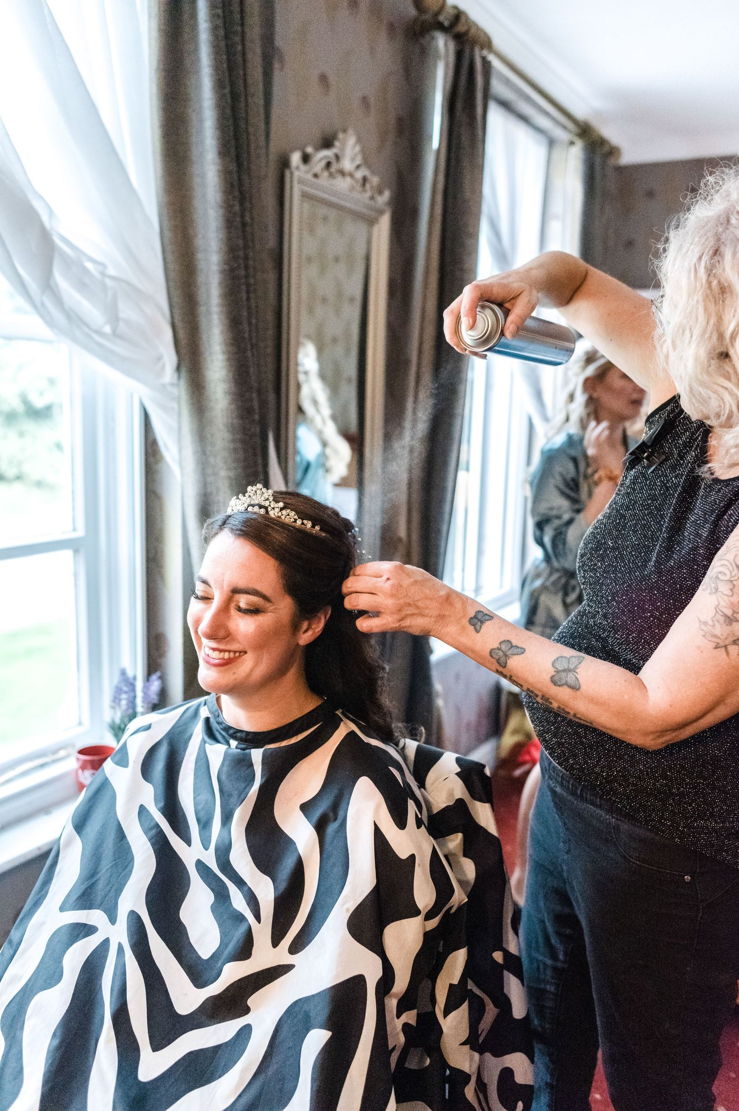Hair styling session during wedding preparations with elegant decor visible in background.