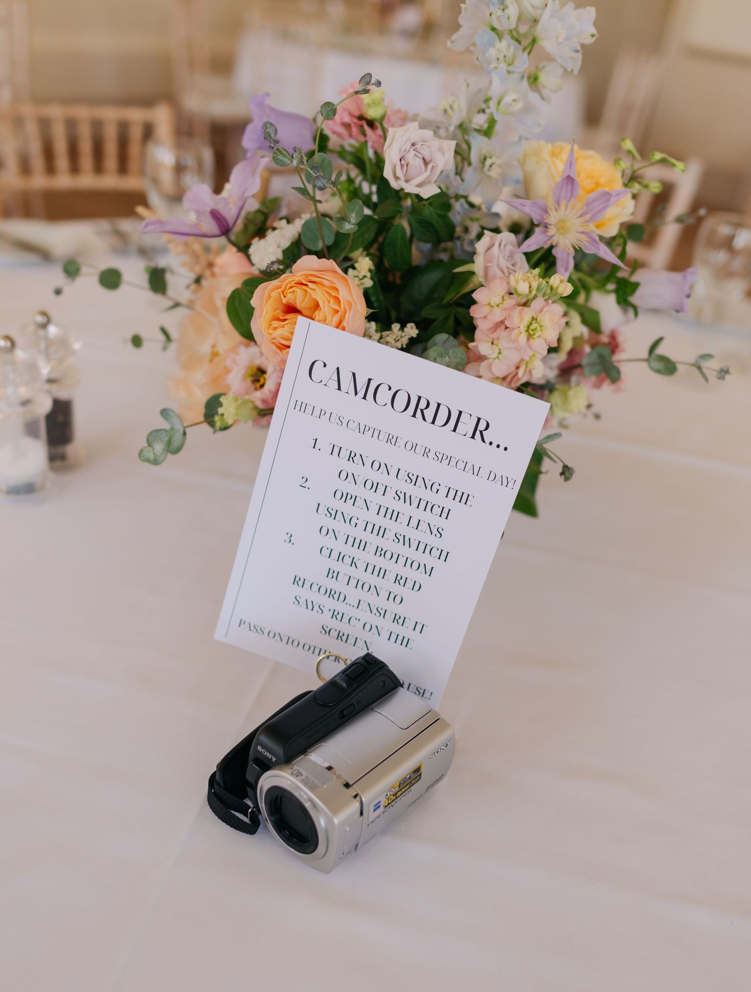 Wedding reception table with delicate floral centerpieces and printed name cards.
