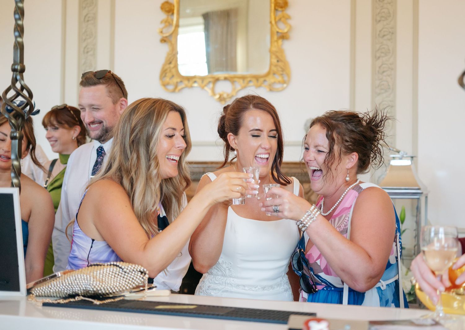 A sequence of candid moments showing wedding guests laughing and celebrating indoors.