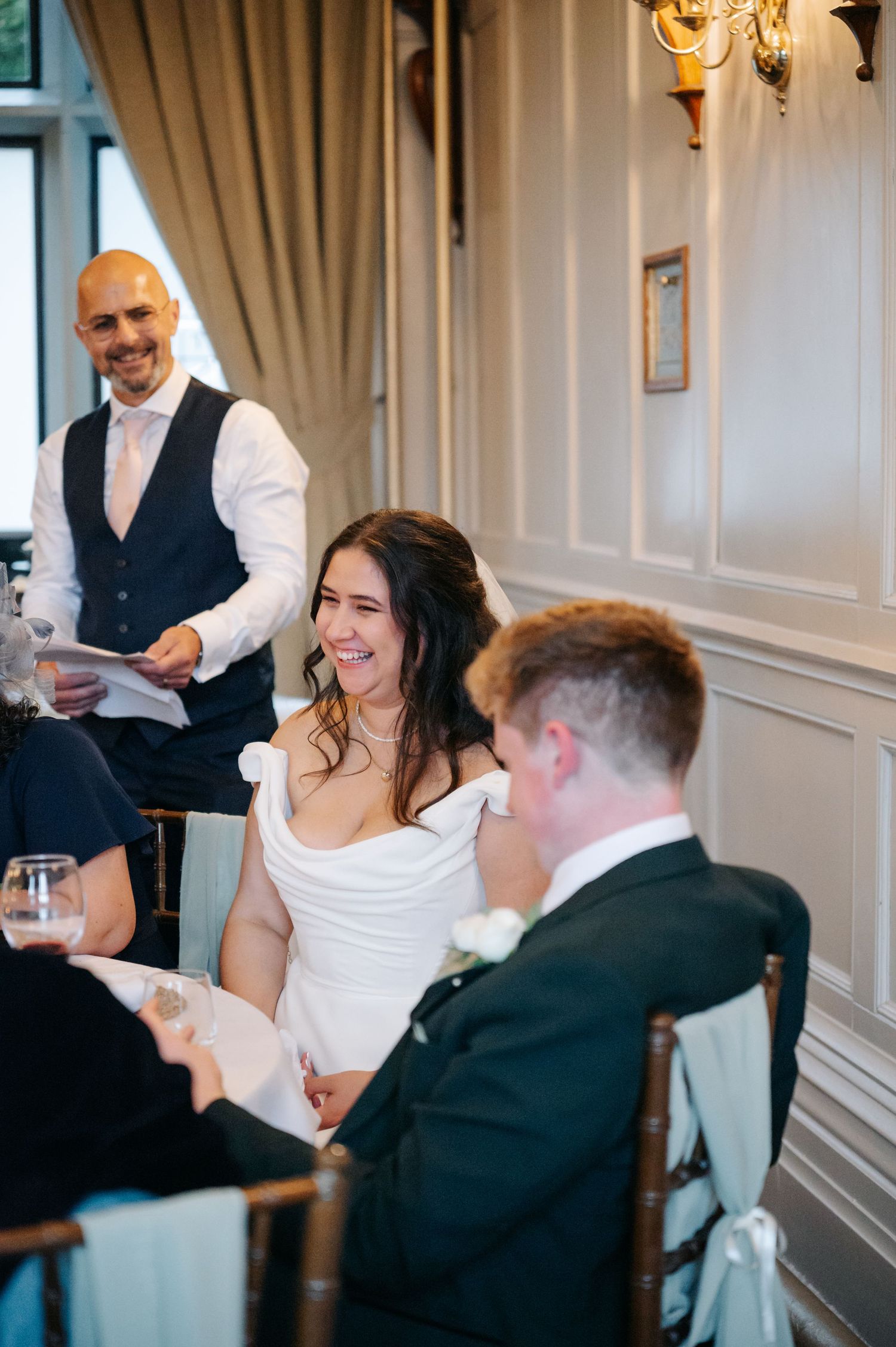 Wedding reception scene with elegant decor and white paneled walls.