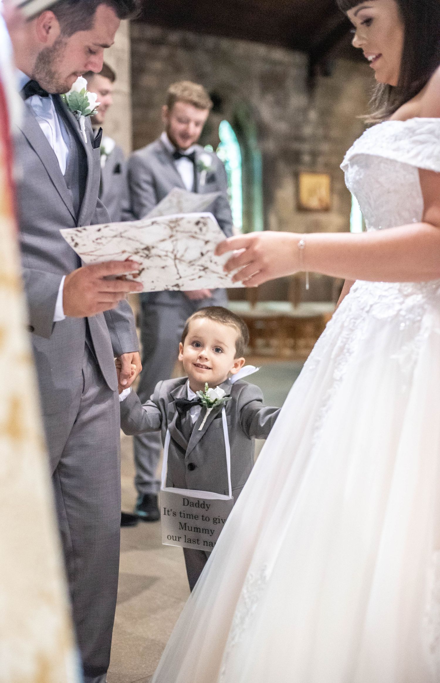 A candid church wedding ceremony moment showing a couple reading vows.