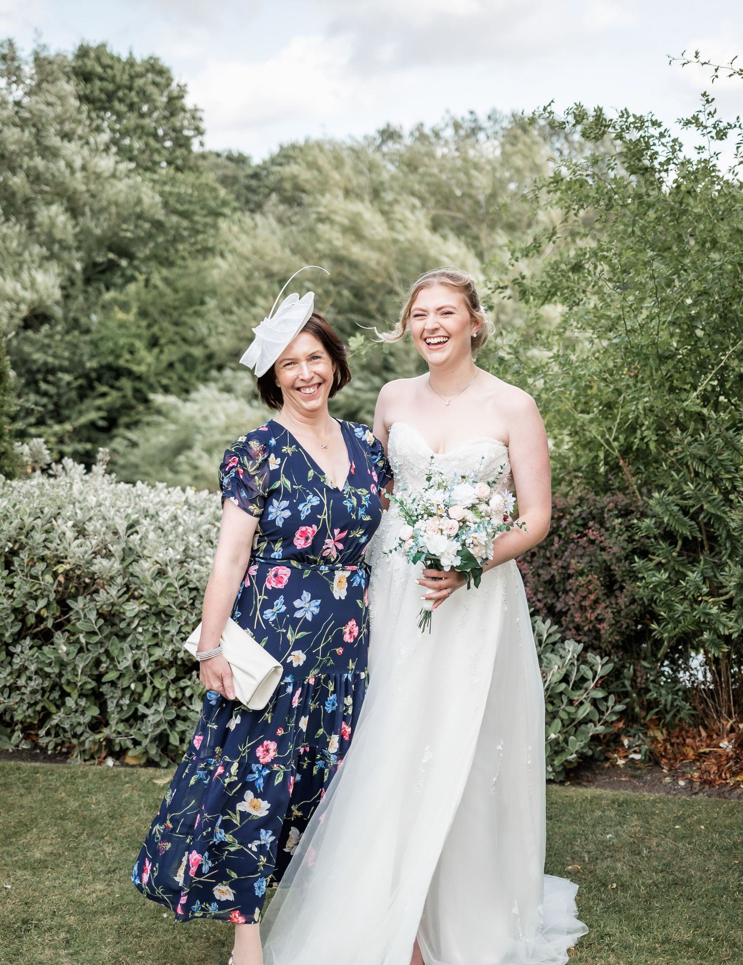 Outdoor wedding portrait with floral garden backdrop.