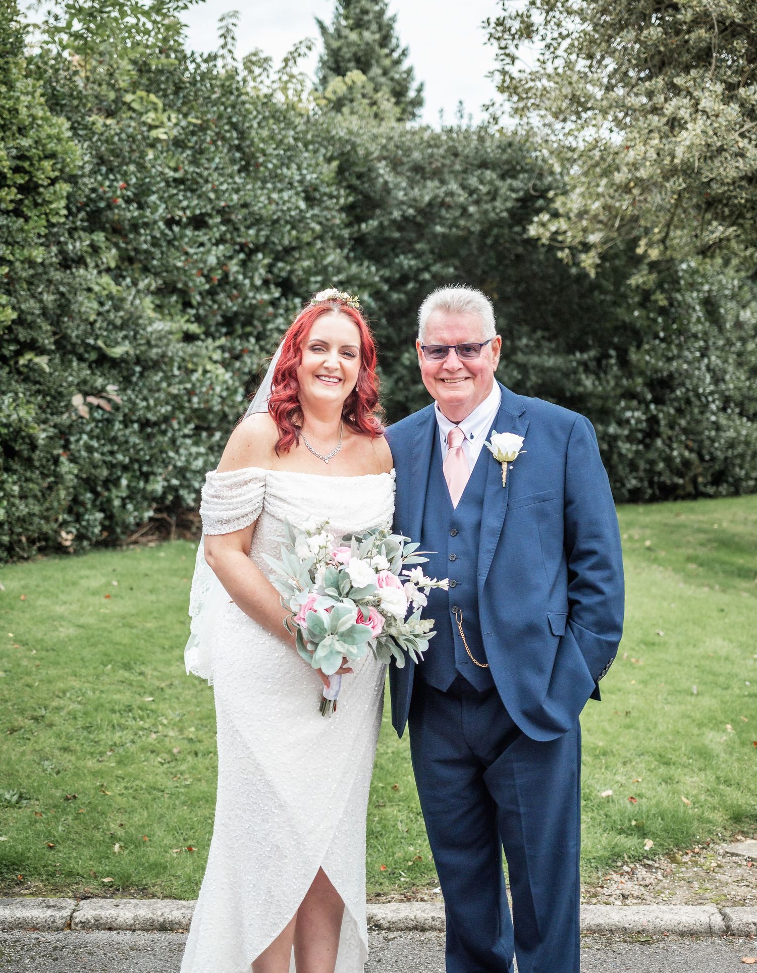 A wedding portrait in a garden setting with elegant formal attire.