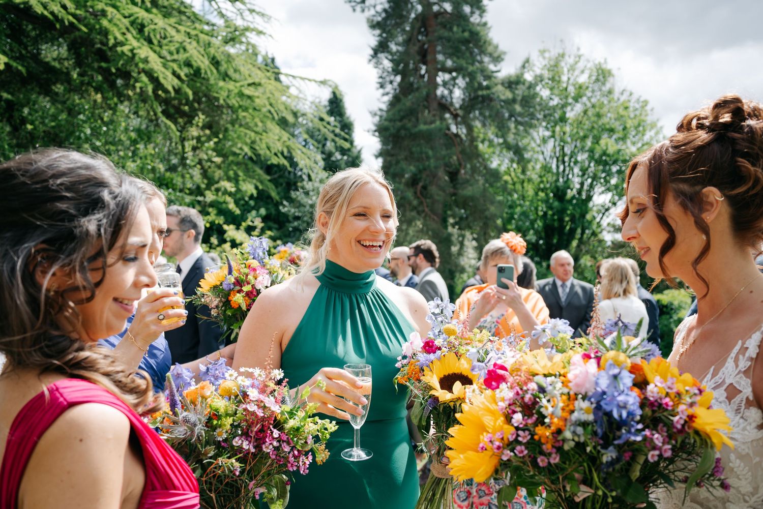 Wedding celebration outdoors with colorful bouquets and festive atmosphere.