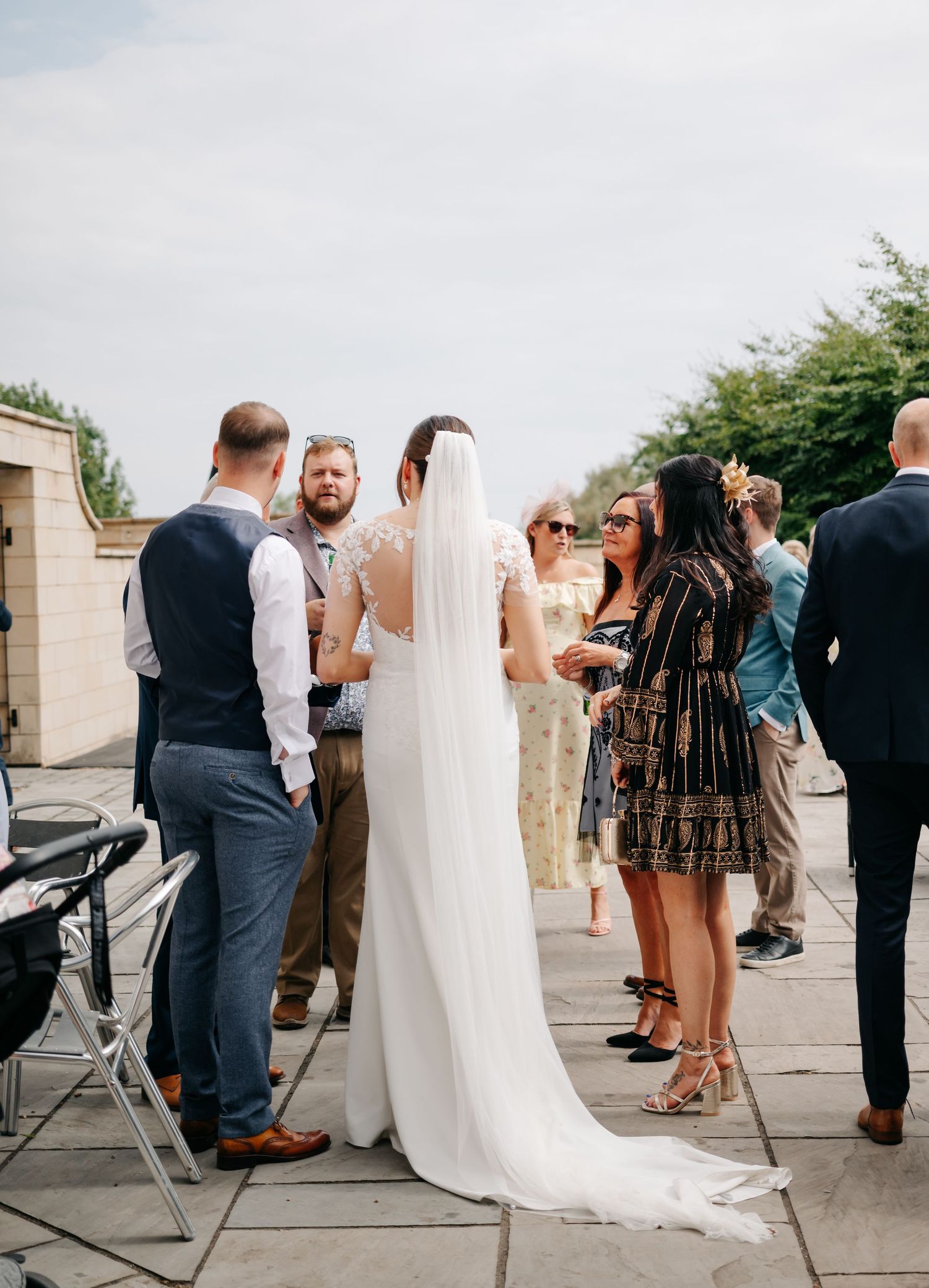 Wedding guests mingle and celebrate during outdoor reception.