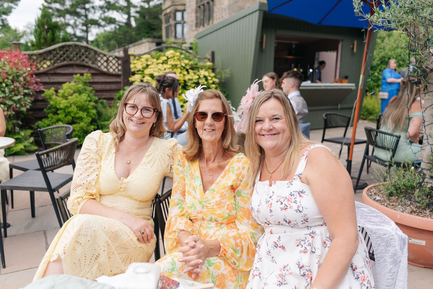 Wedding guests in yellow and white dresses enjoying an outdoor celebration.