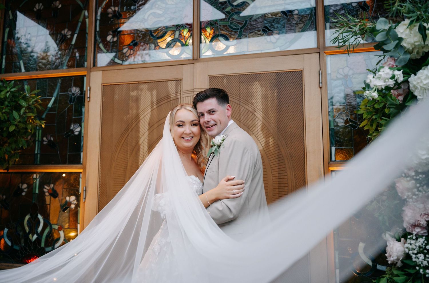 Elegant outdoor wedding ceremony setup with floral arrangements and white drapery.