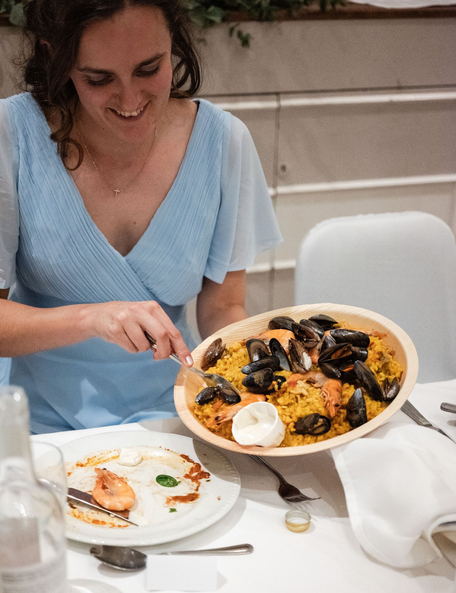 Plates of seafood paella with mussels and shrimp are served at a casual dining table.
