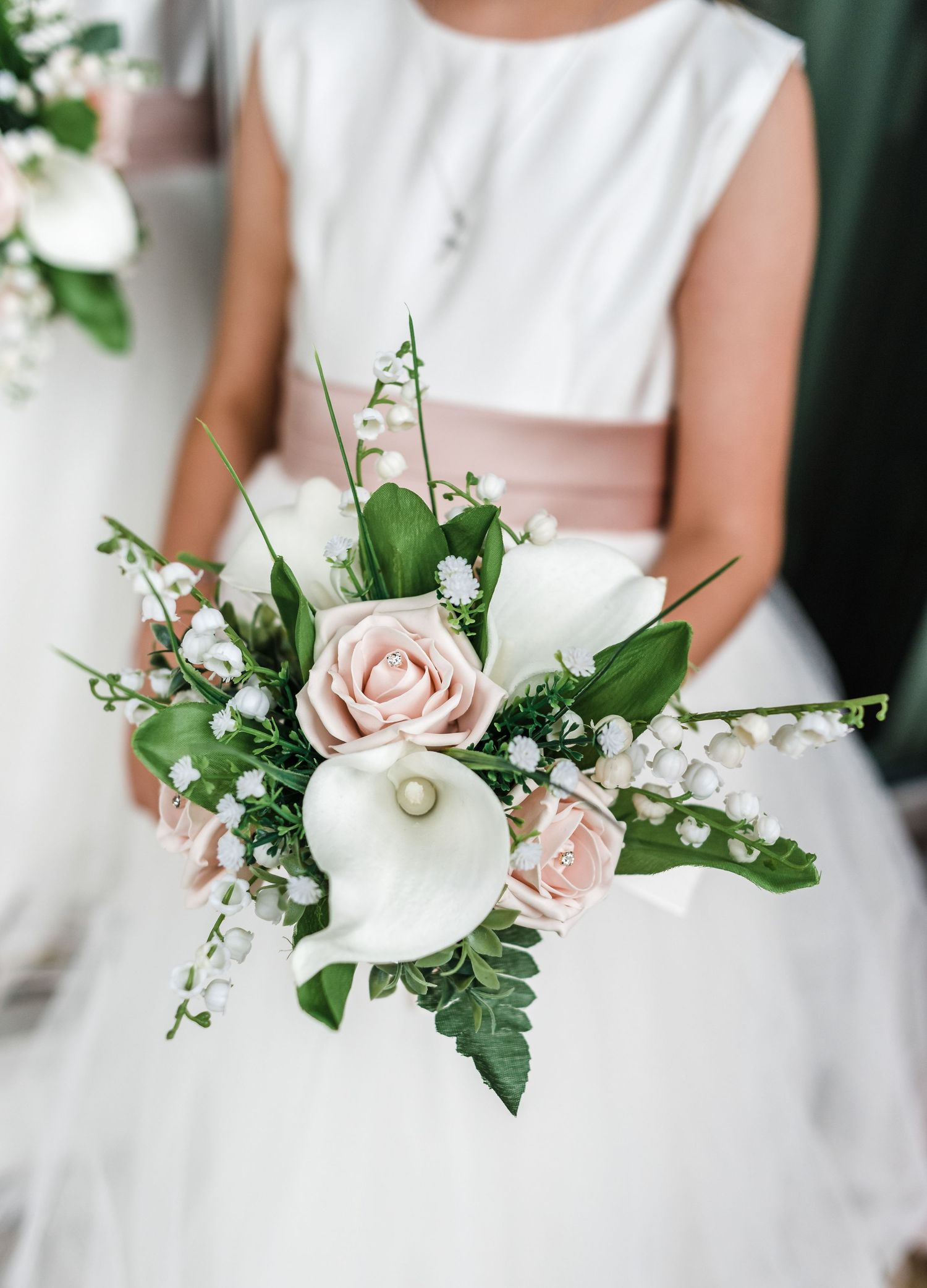 Elegant bridal bouquet with white calla lilies, pink roses, and delicate greenery.