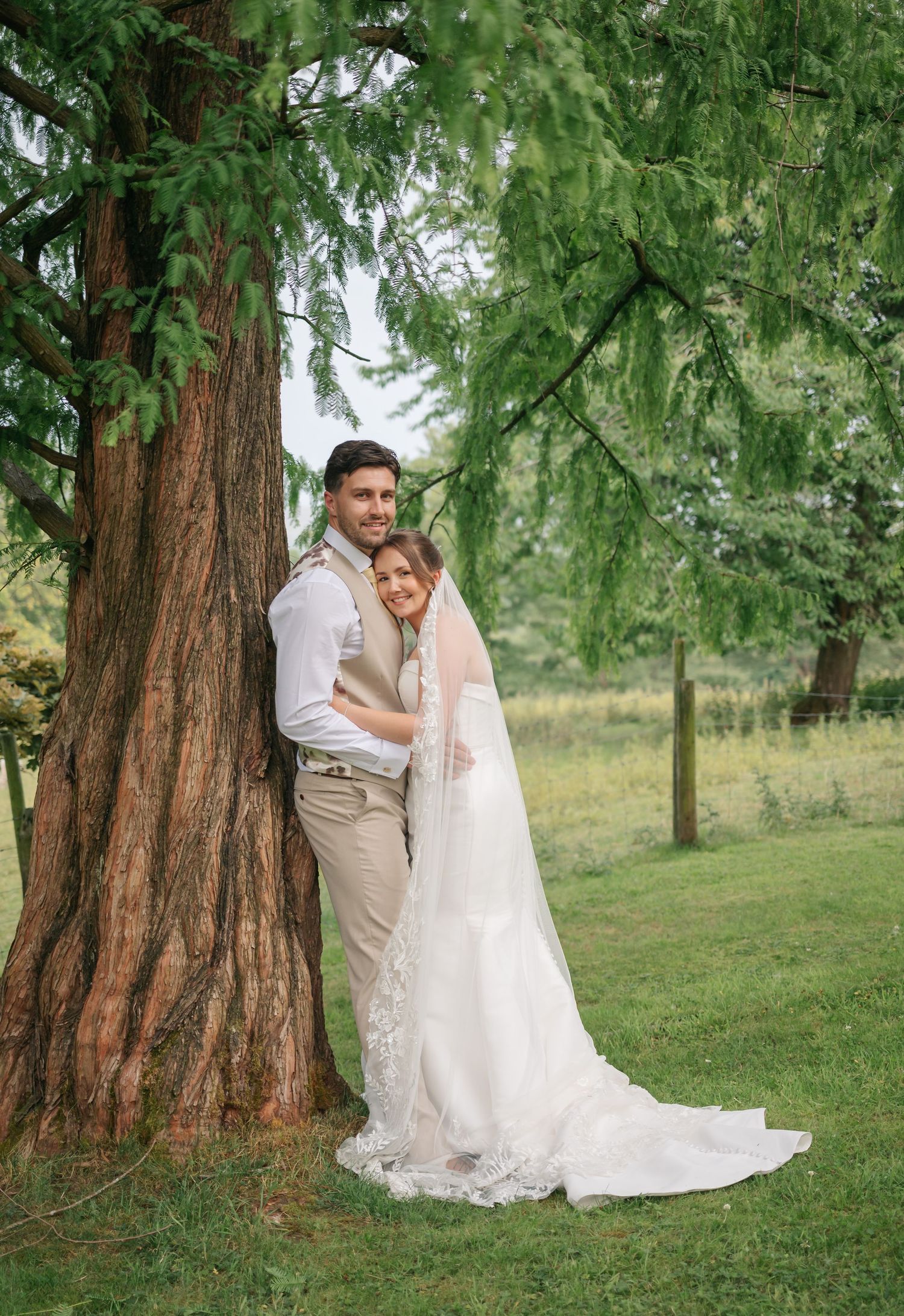Romantic wedding portraits under beautiful redwood trees in a lush garden setting.