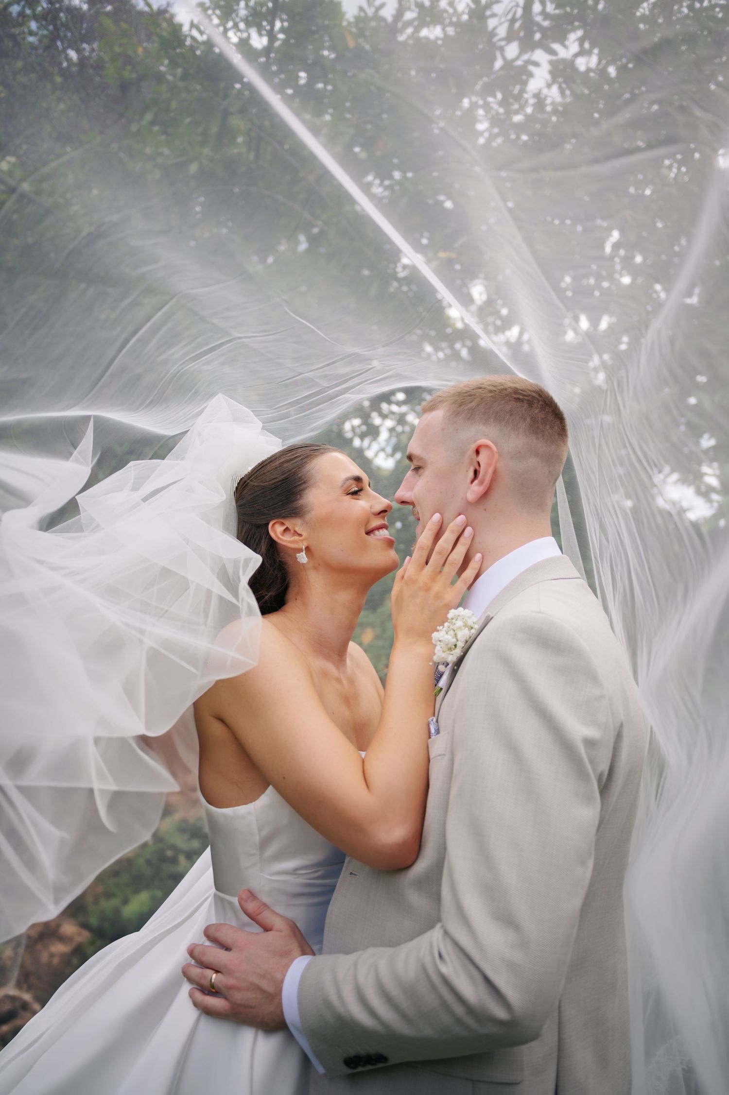 A flowing wedding veil creates a dreamy atmosphere in black and white photography.