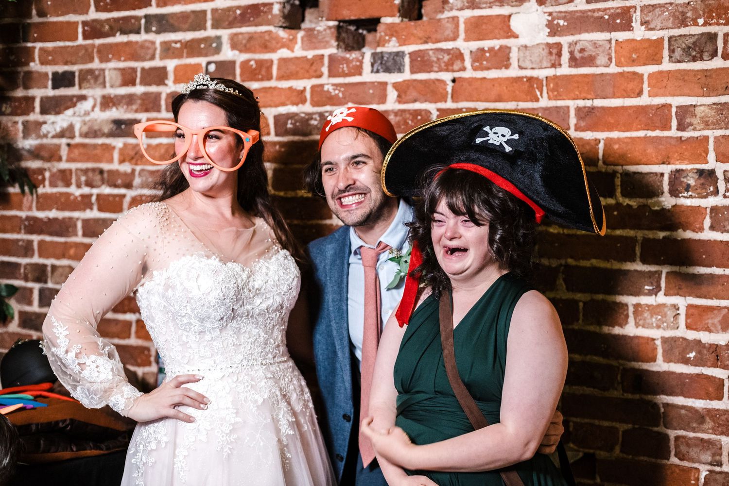 Wedding guests pose with props and costumes for fun photo booth picture.