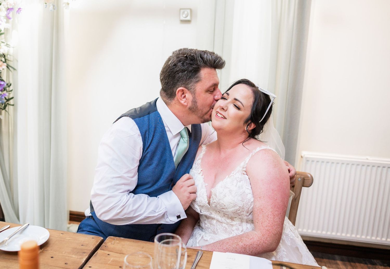 Intimate wedding moment captured indoors with soft natural lighting.